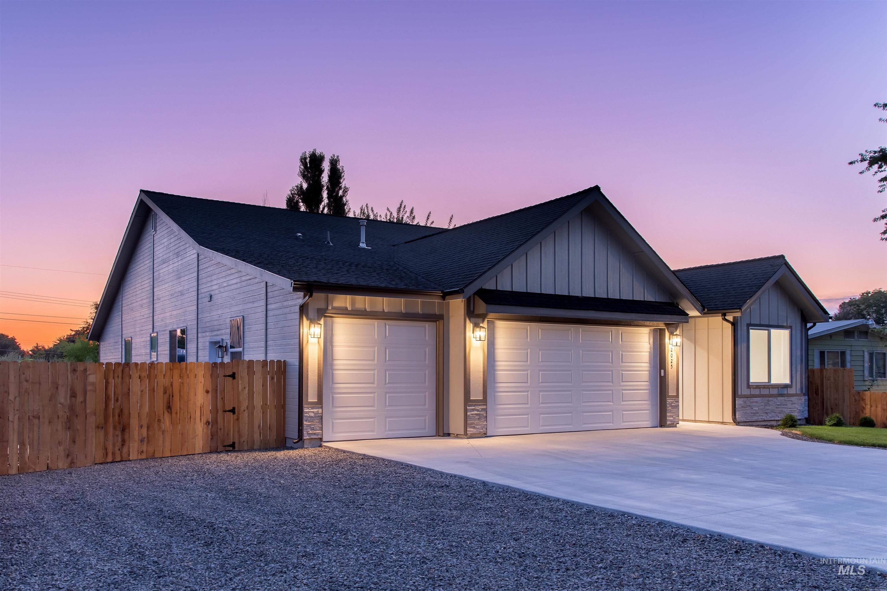 View of front of home featuring board and batten siding, driveway, an attached garage, and a shingled roof