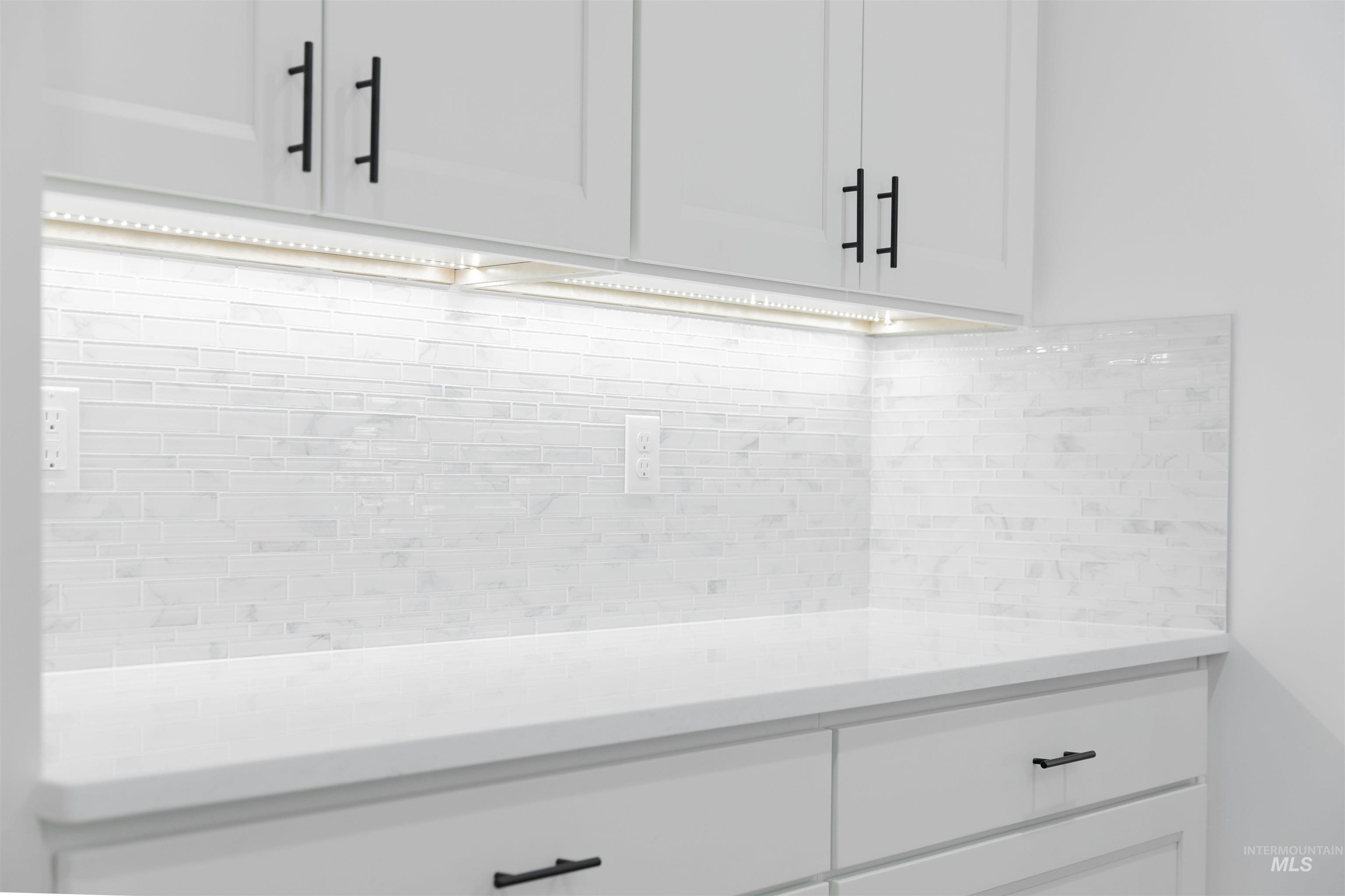 Detailed view of light countertops and white cabinetry