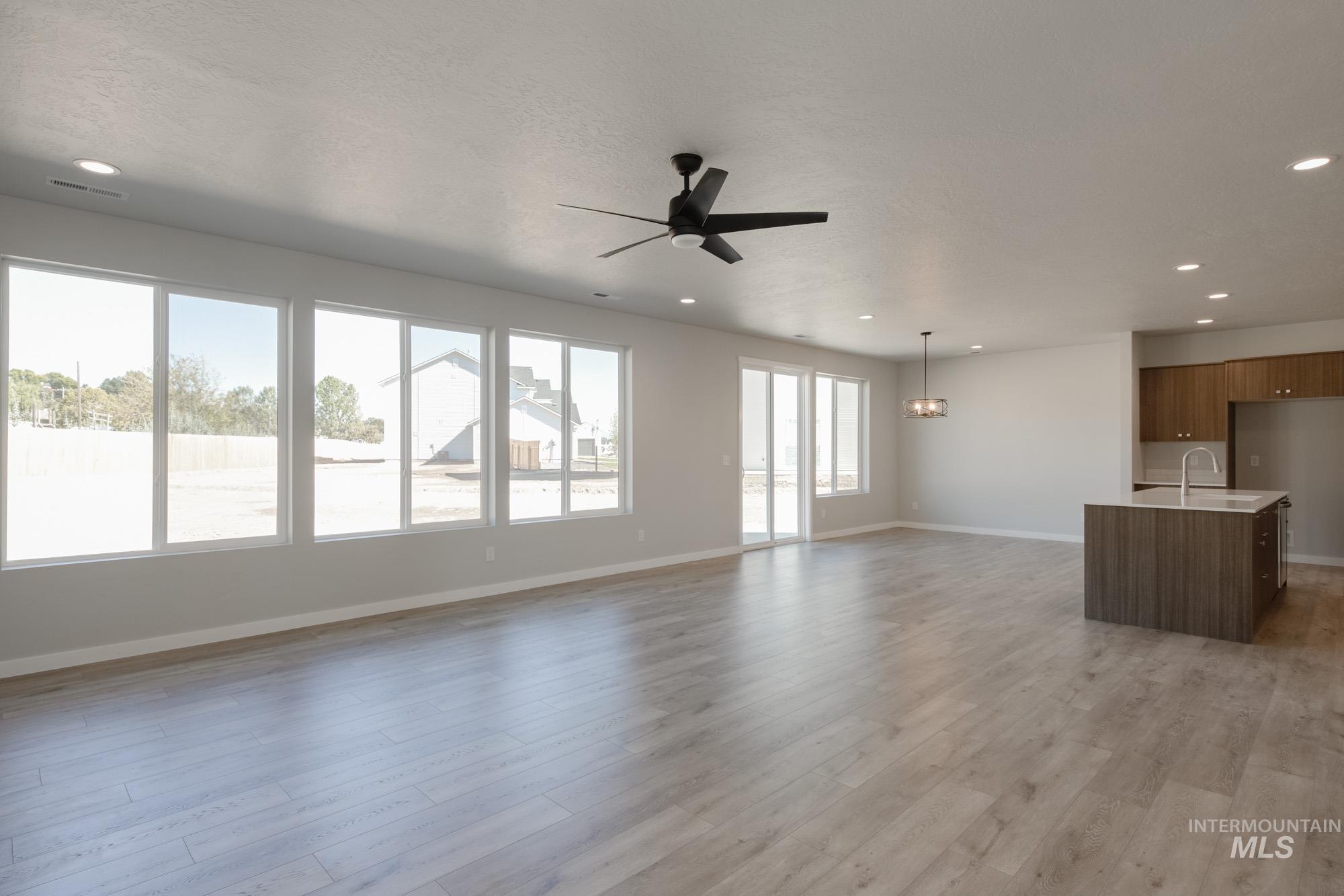 Unfurnished living room with light wood-style flooring, recessed lighting, and a ceiling fan