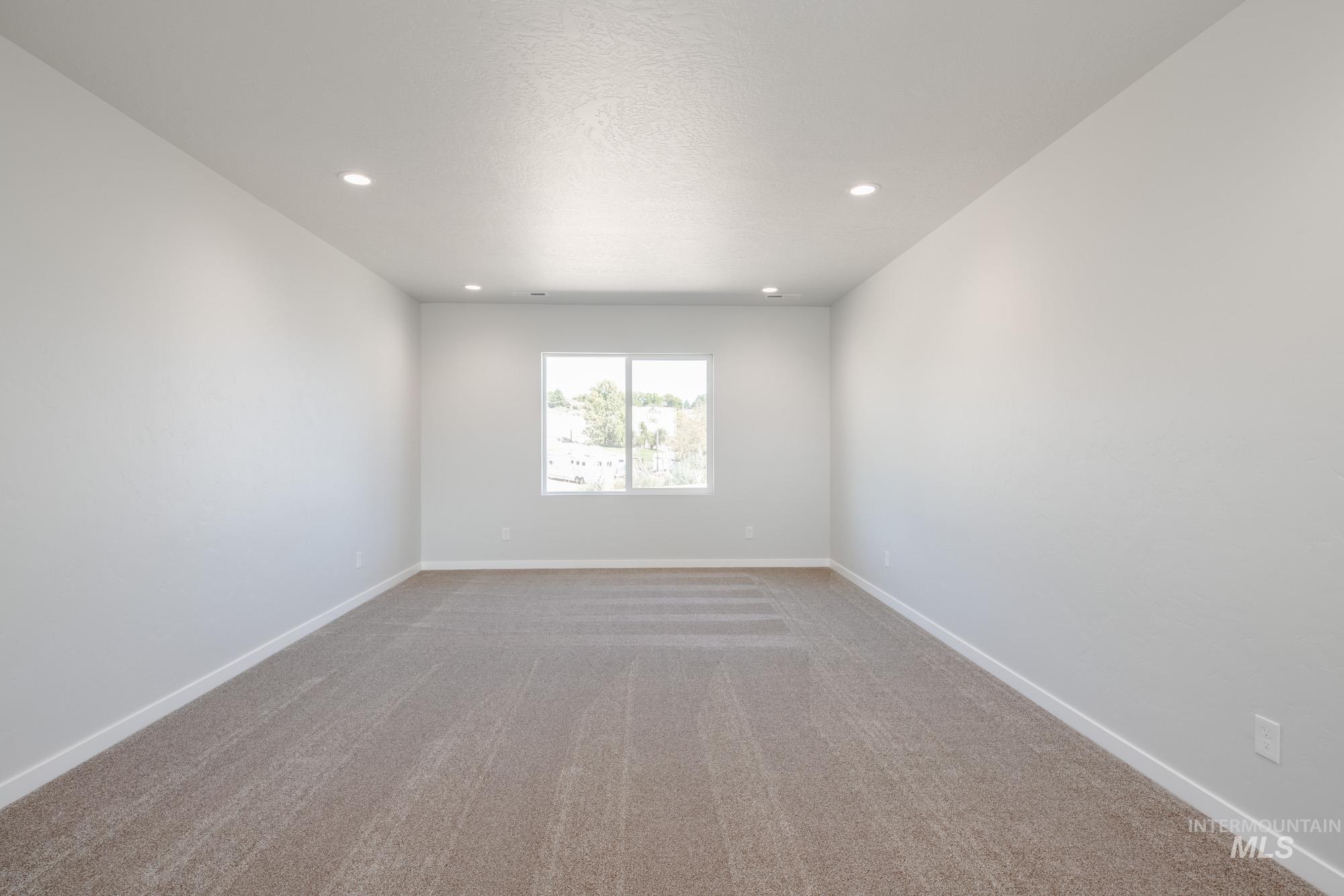 Unfurnished room with light colored carpet, recessed lighting, and a textured ceiling
