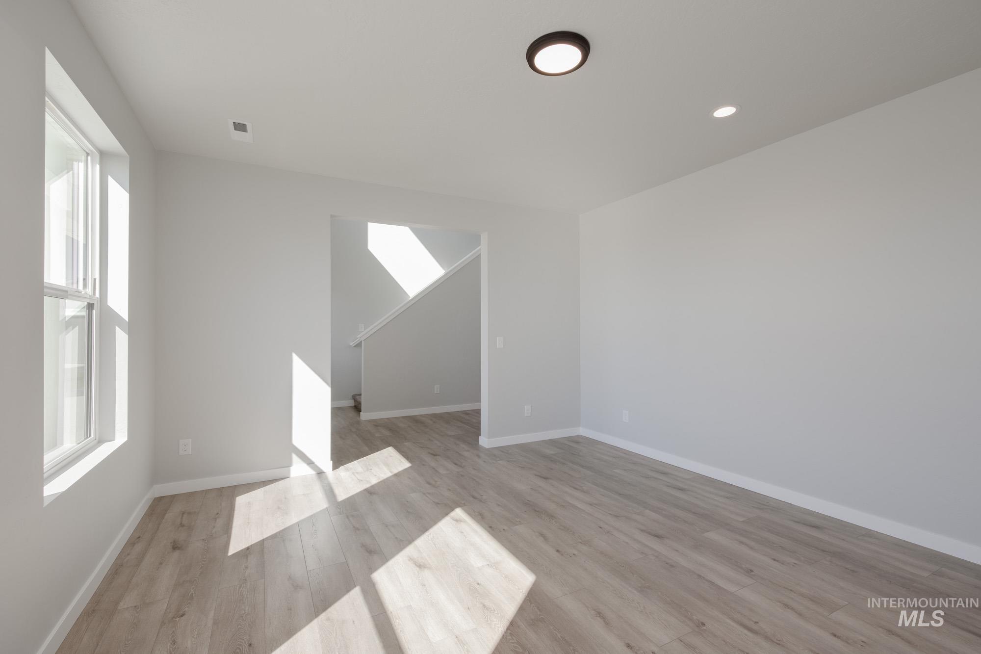 Unfurnished living room with light wood-type flooring and recessed lighting