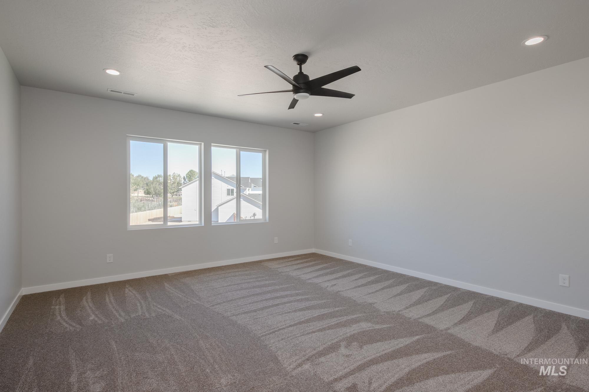 Carpeted spare room with a ceiling fan, recessed lighting, and a textured ceiling