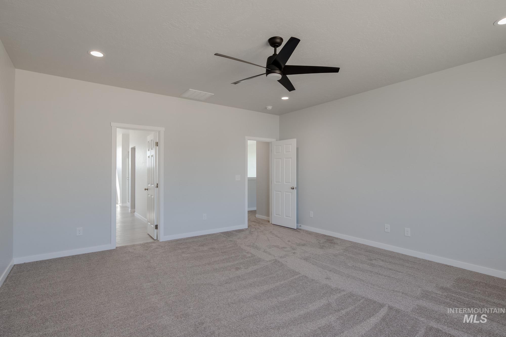 Unfurnished bedroom featuring light carpet, ceiling fan, and recessed lighting