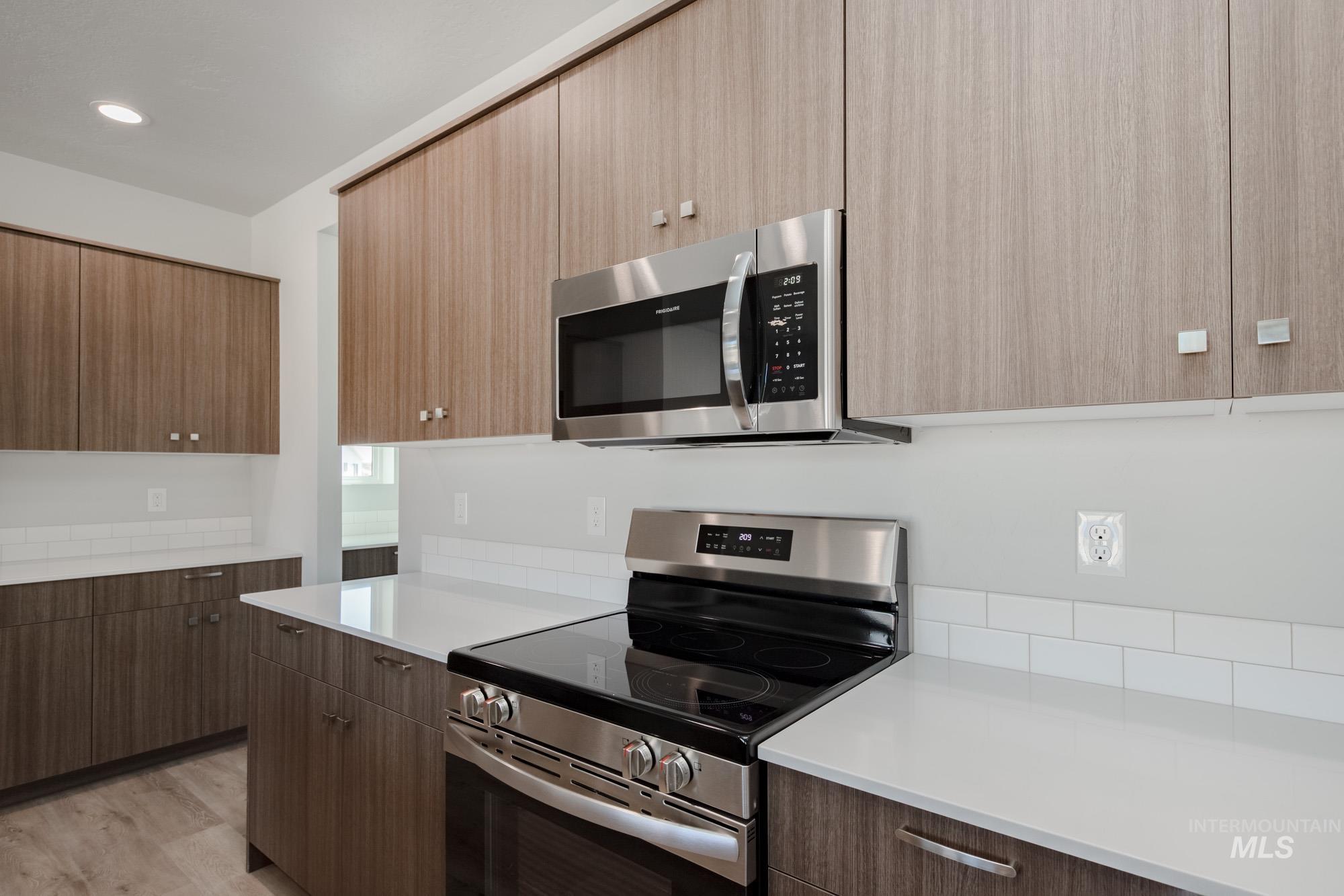 Kitchen with appliances with stainless steel finishes, modern cabinets, and light wood-style floors