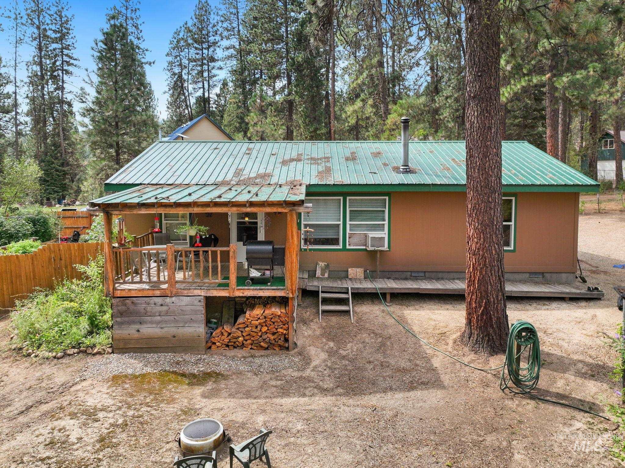 Back of house featuring crawl space, a deck, and a metal roof