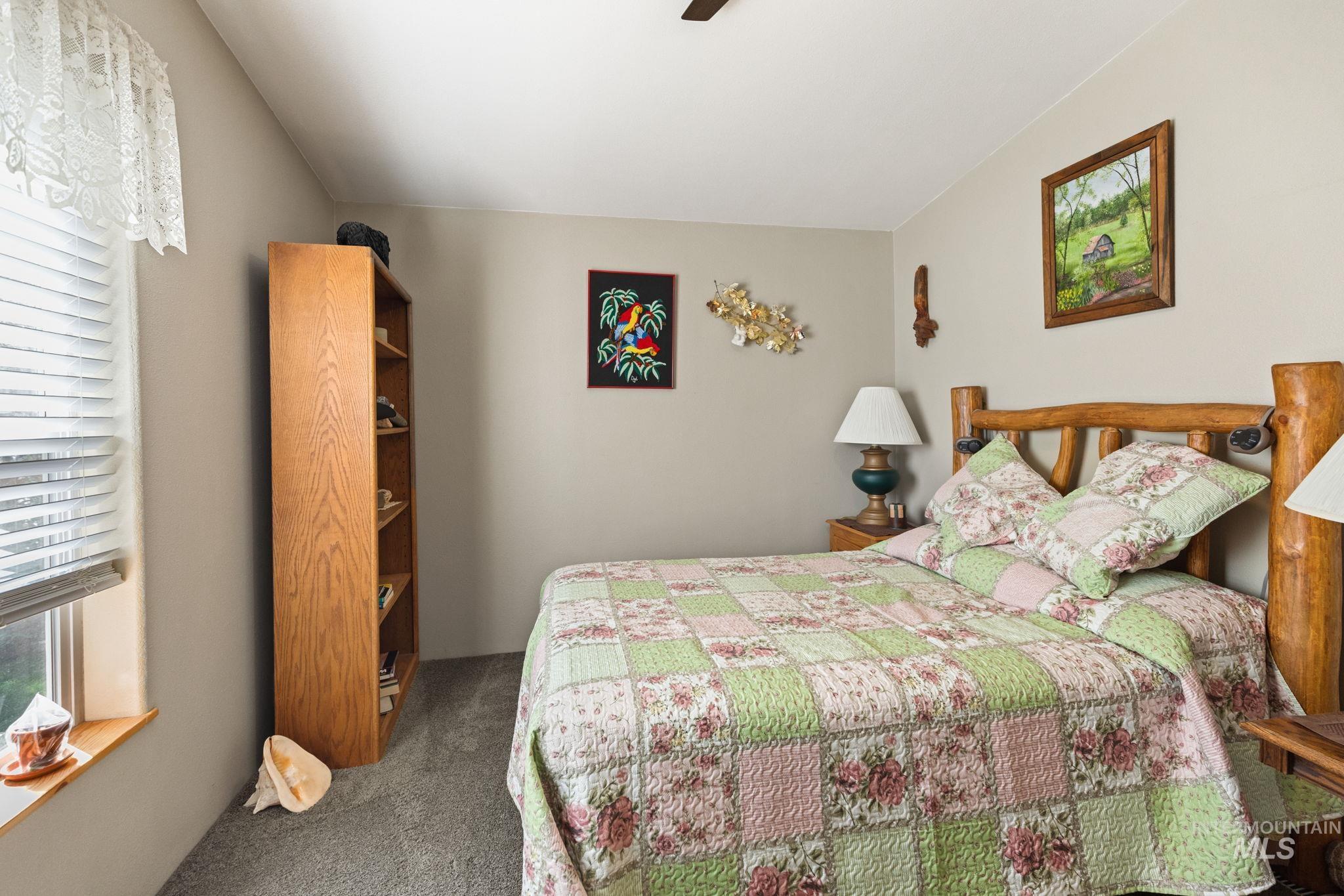Bedroom featuring dark carpet and a ceiling fan