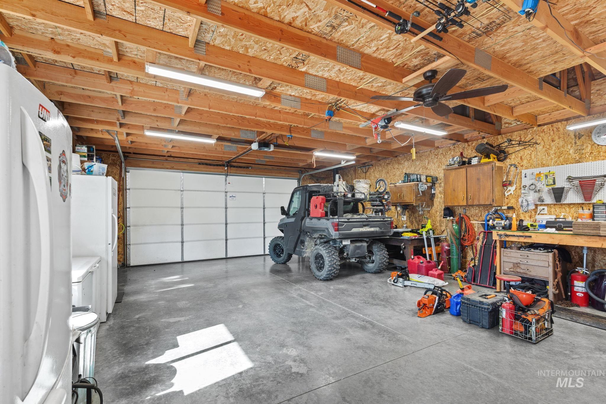 Garage featuring freestanding refrigerator and a workshop area