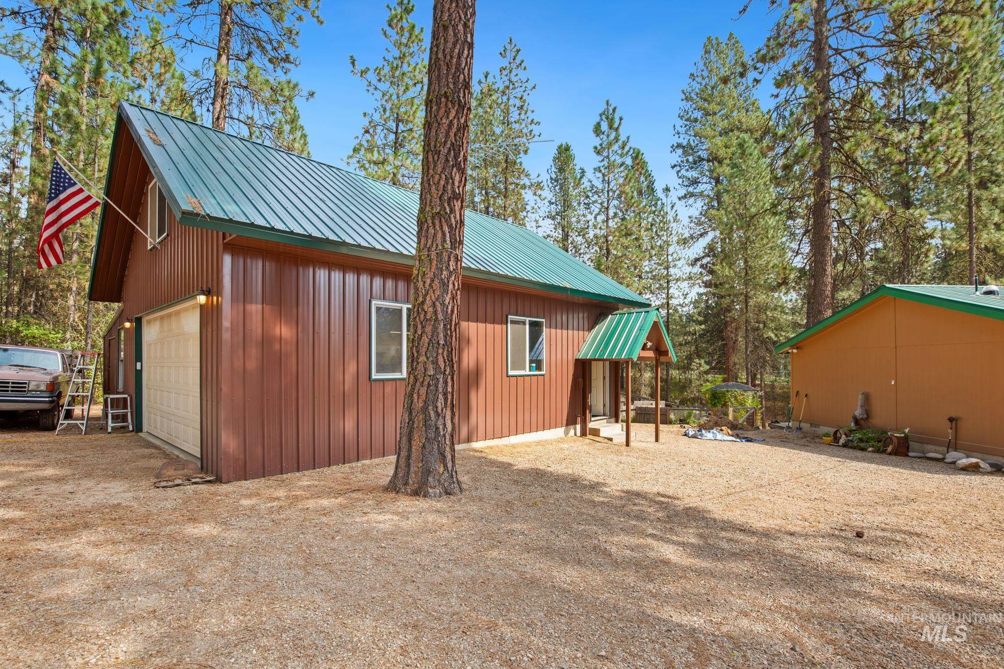 View of home's exterior featuring a metal roof, an outbuilding, and a garage