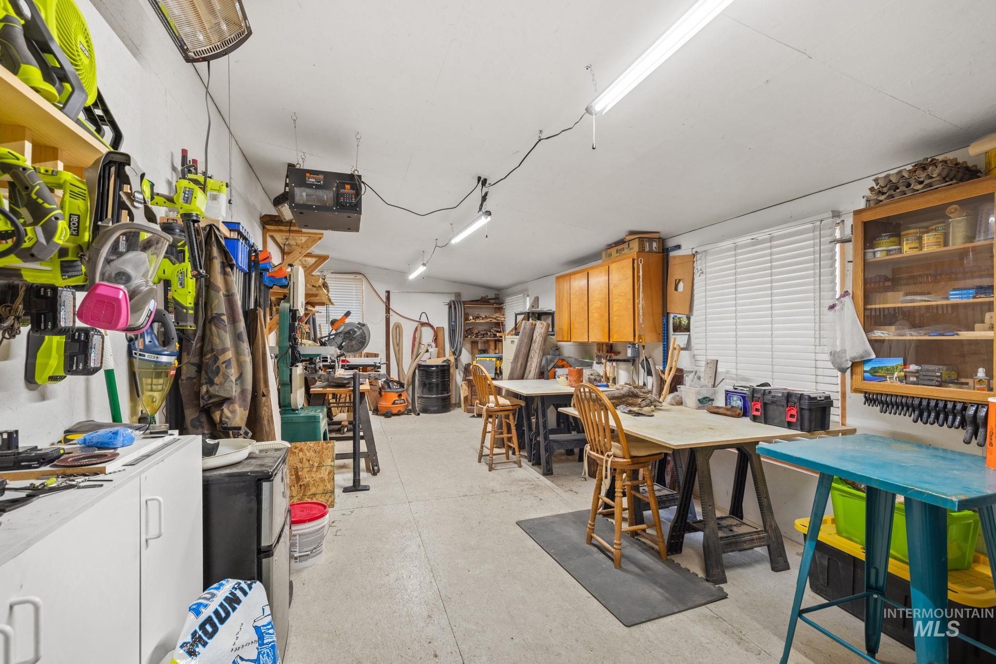 Garage with a workshop area, stainless steel refrigerator, washer / dryer, and a garage door opener