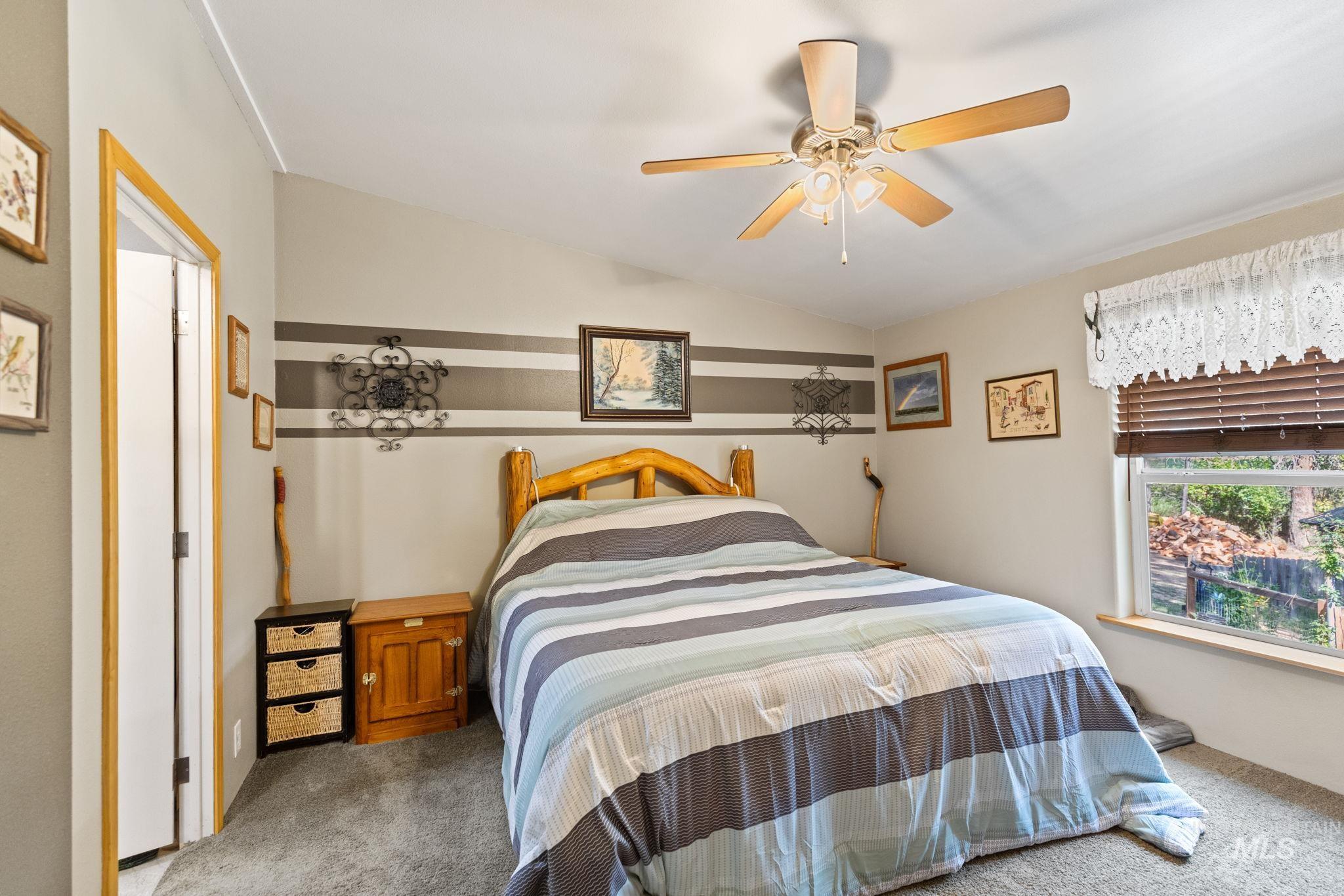 Bedroom featuring carpet floors, a ceiling fan, and vaulted ceiling