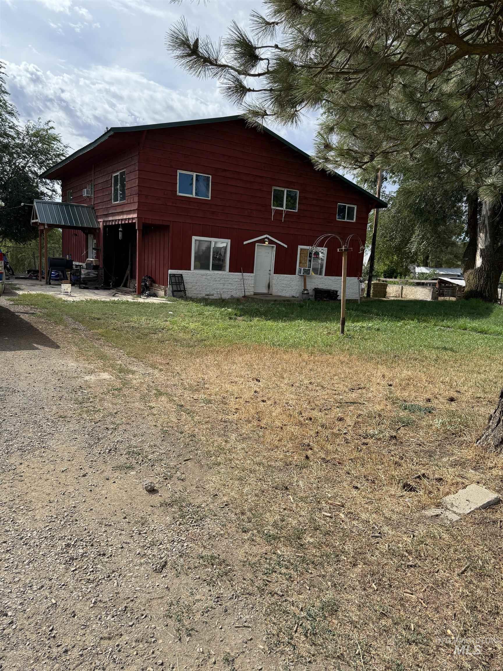 Rear view of house with board and batten siding, a patio, and a lawn
