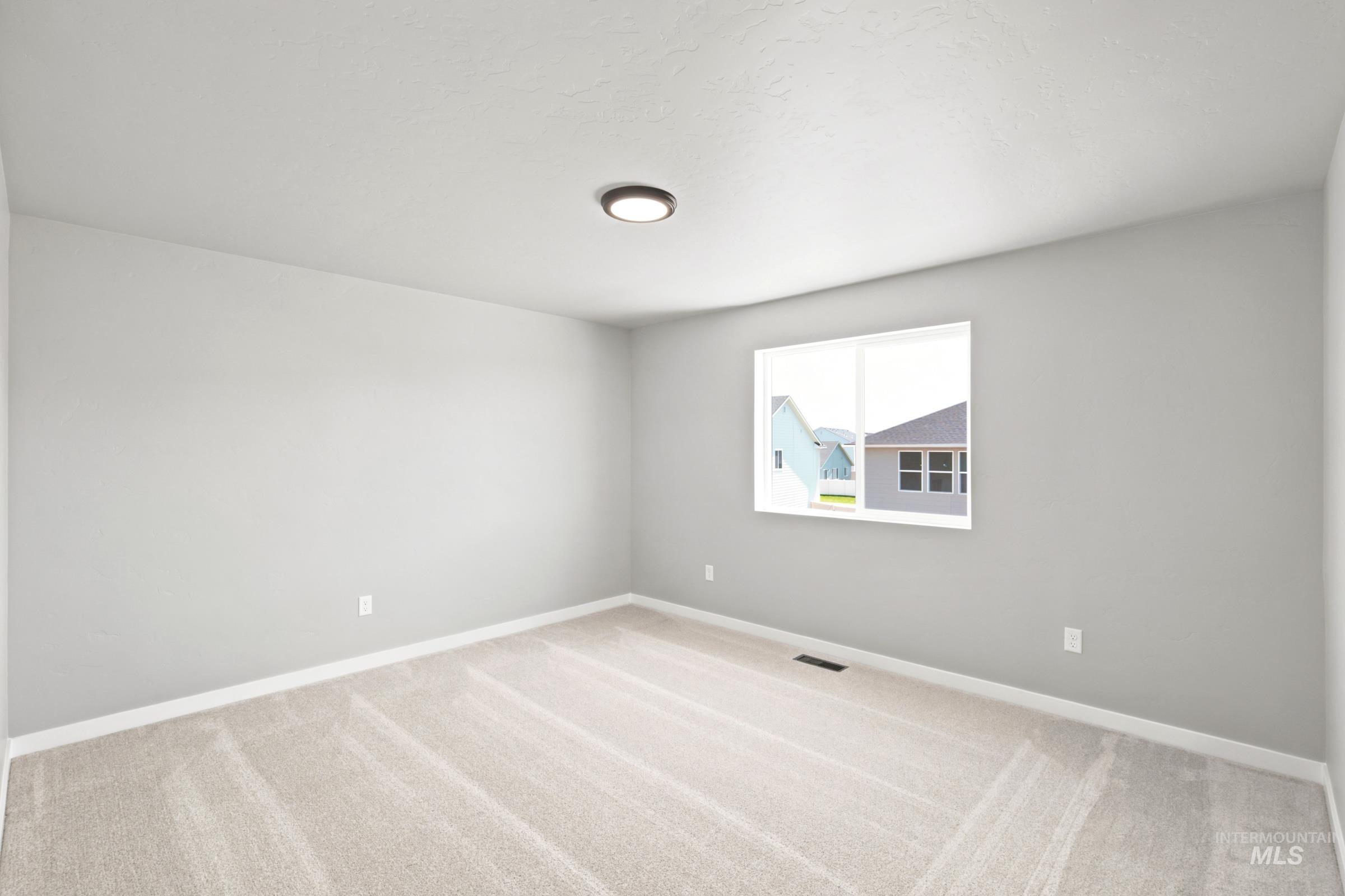 Neutral gray walls with white baseboards and neutral carpet flooring
