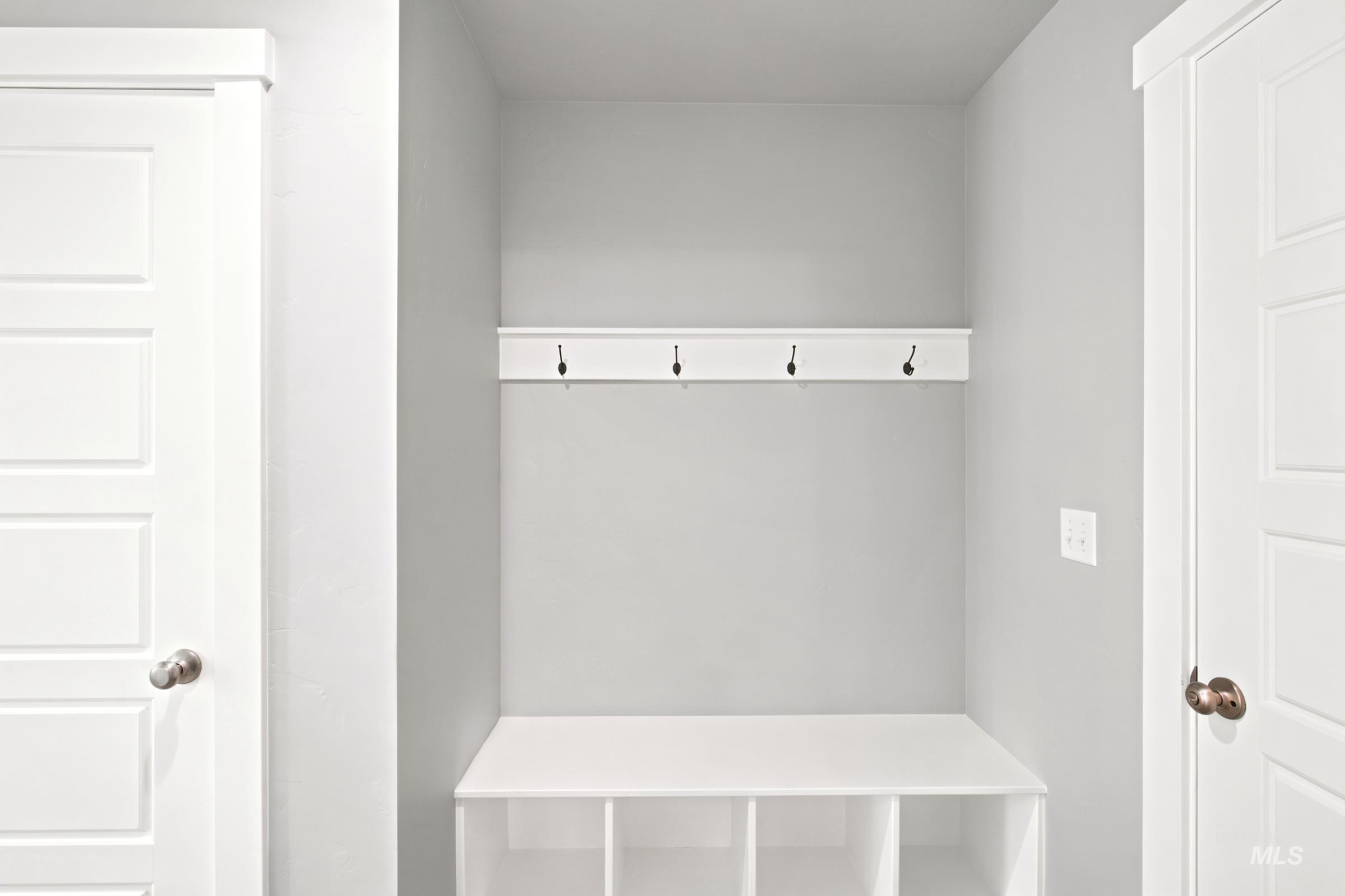 Built-in entryway bench with integrated cubby storage, featuring a coordinating wall-mounted coat rack with four dark-finish hooks