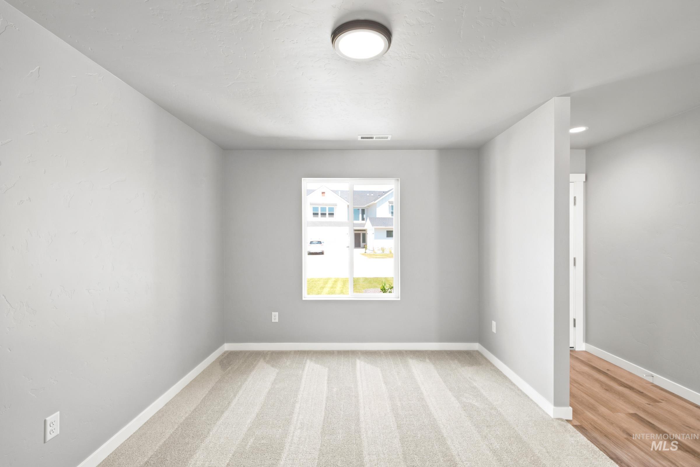 Room featuring neutral-toned carpet, a single window, and a flush-mount ceiling light