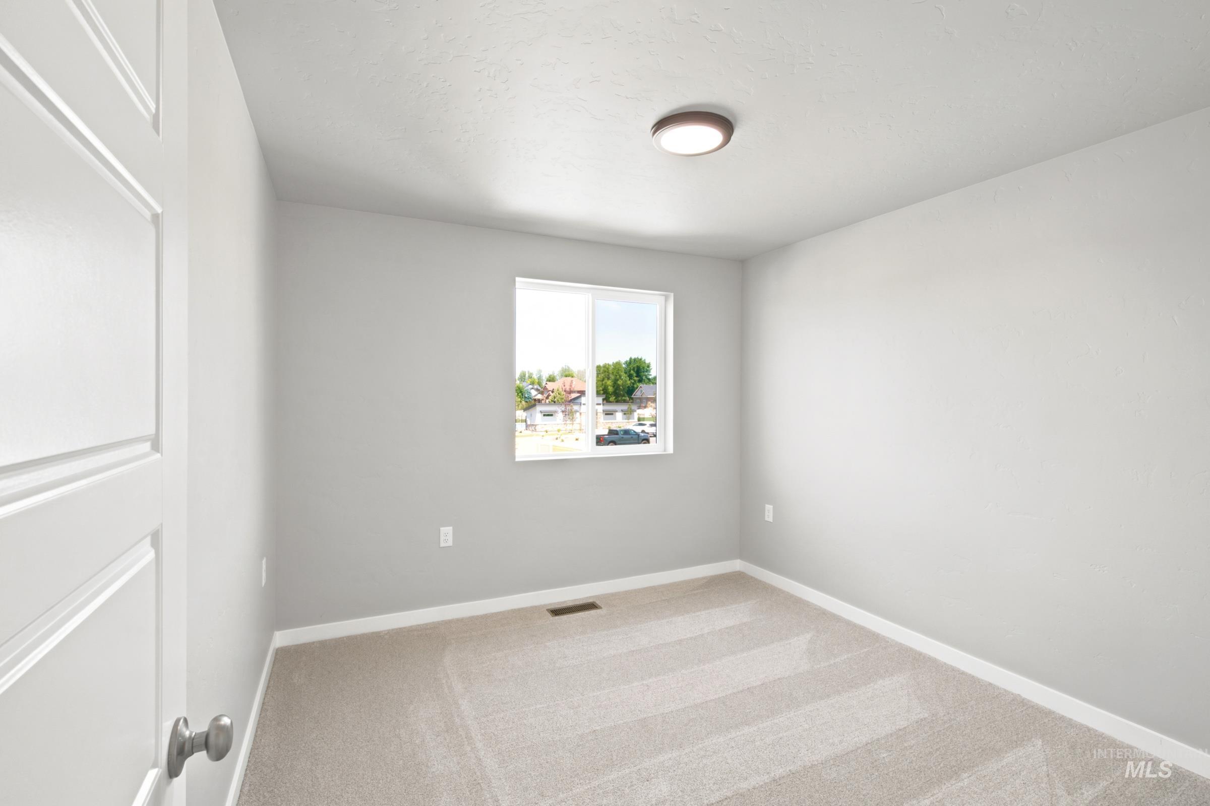 Carpeted room featuring light gray walls, a white trim baseboard, and a flush mount ceiling light fixture