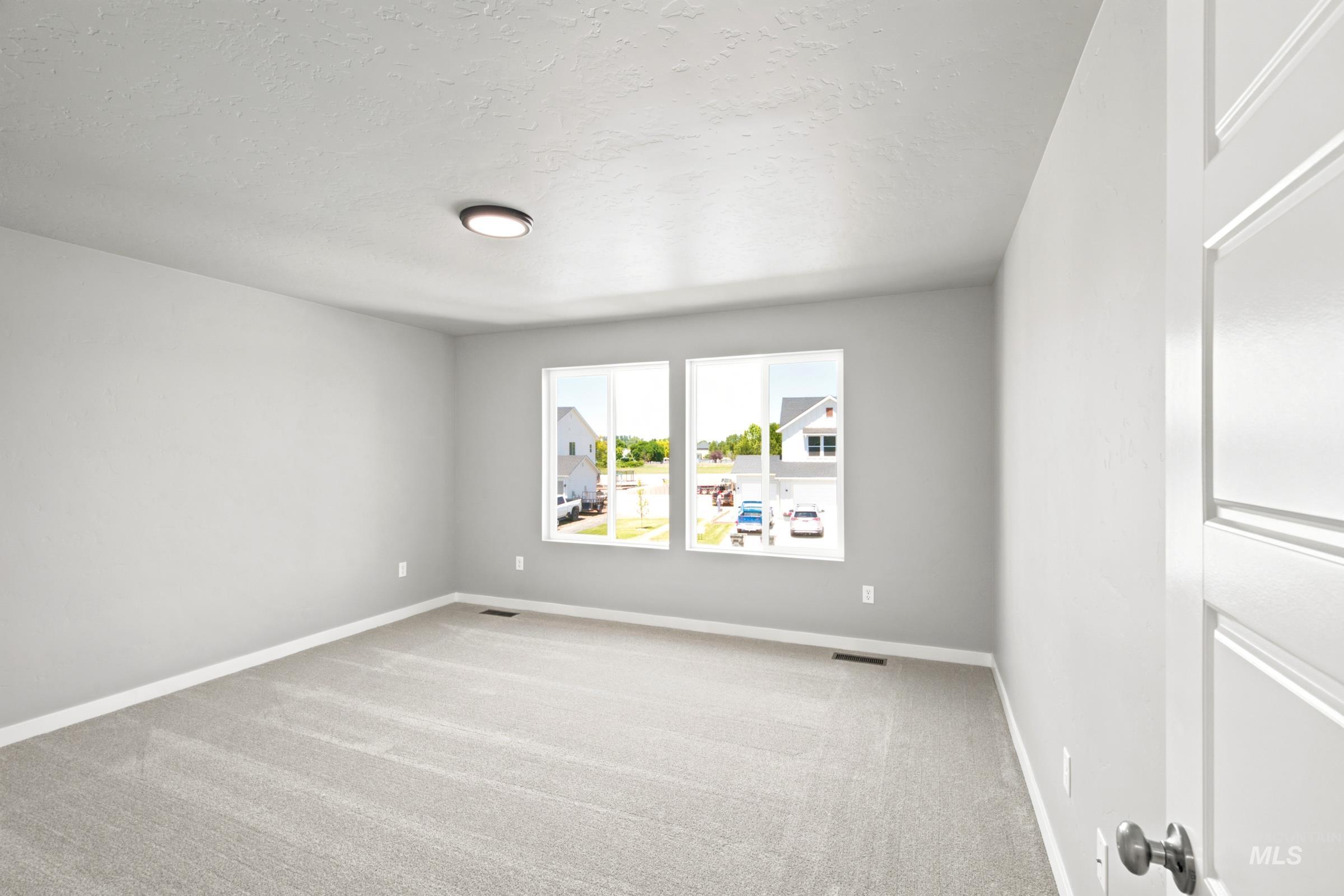 Carpeted room with light grey walls, white trim, and a flush-mount ceiling light