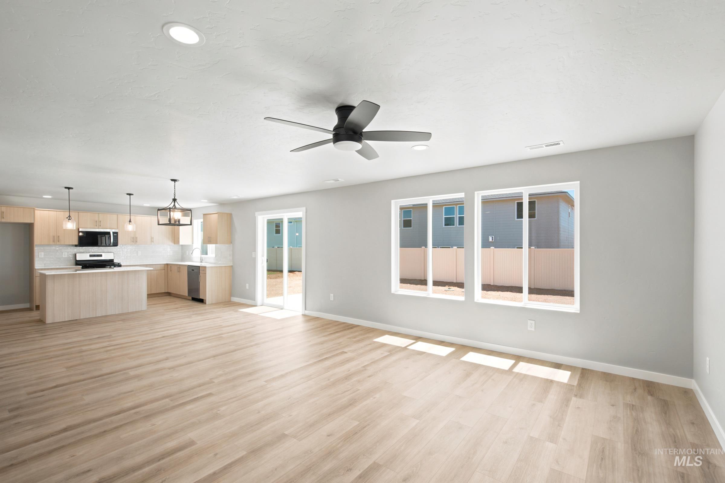 Open-concept living area featuring wood-finish flooring, recessed lighting, and a contemporary ceiling fan