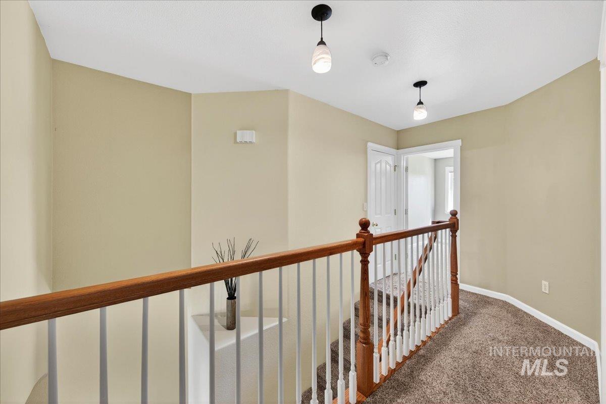 Hallway featuring an upstairs landing and carpet