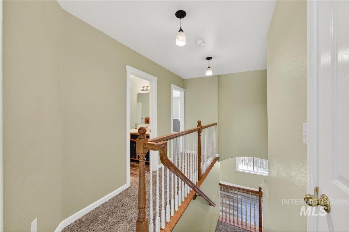 Hallway with carpet flooring and an upstairs landing