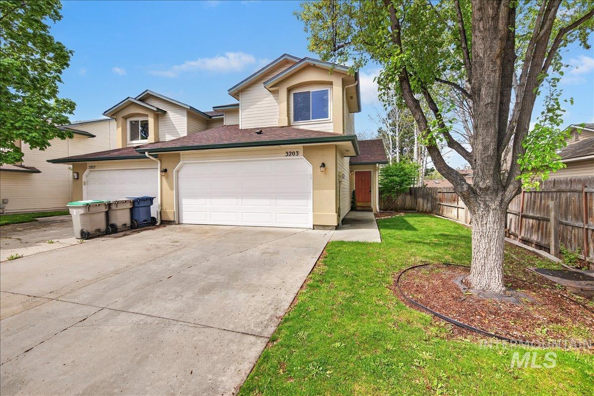 Traditional-style house with driveway, stucco siding, and roof with shingles