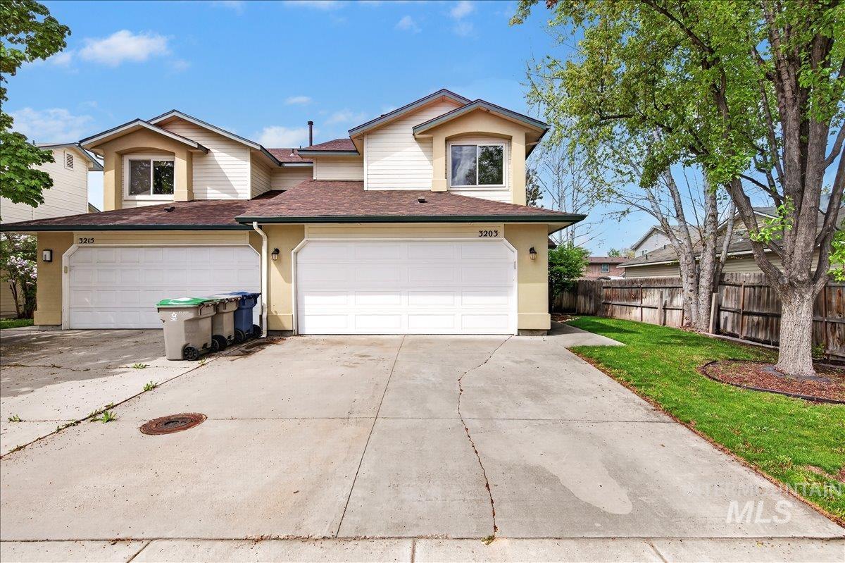 Traditional home with roof with shingles, driveway, and an attached garage