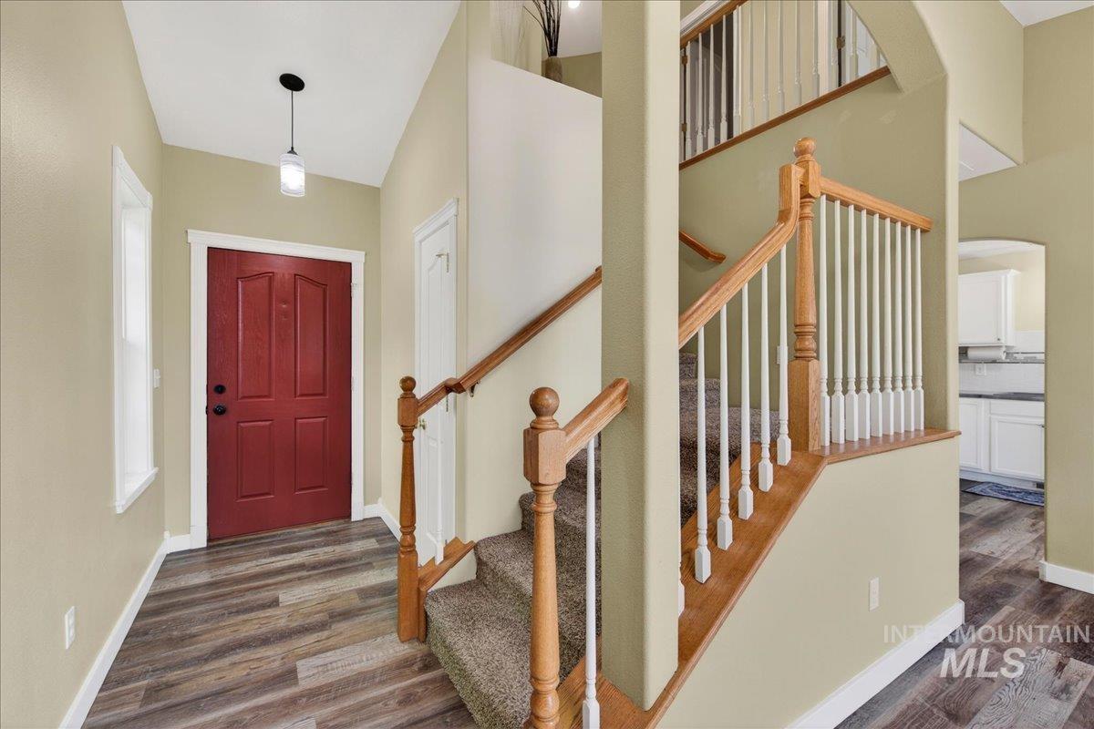 Foyer with dark wood finished floors and arched walkways
