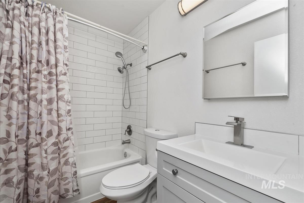 Bathroom with vanity and shower / bath combination with curtain