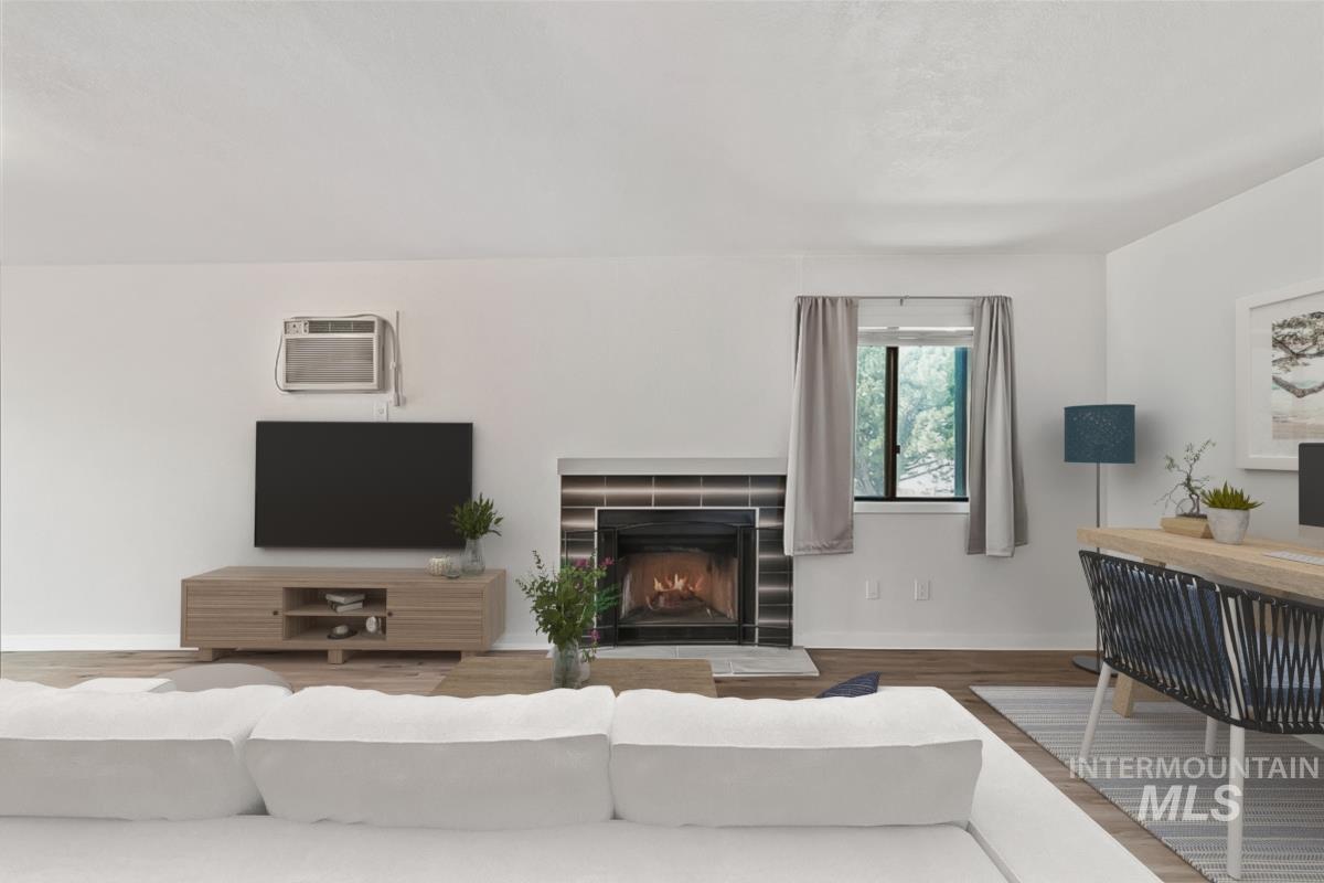 Living room with wood finished floors and a tiled fireplace