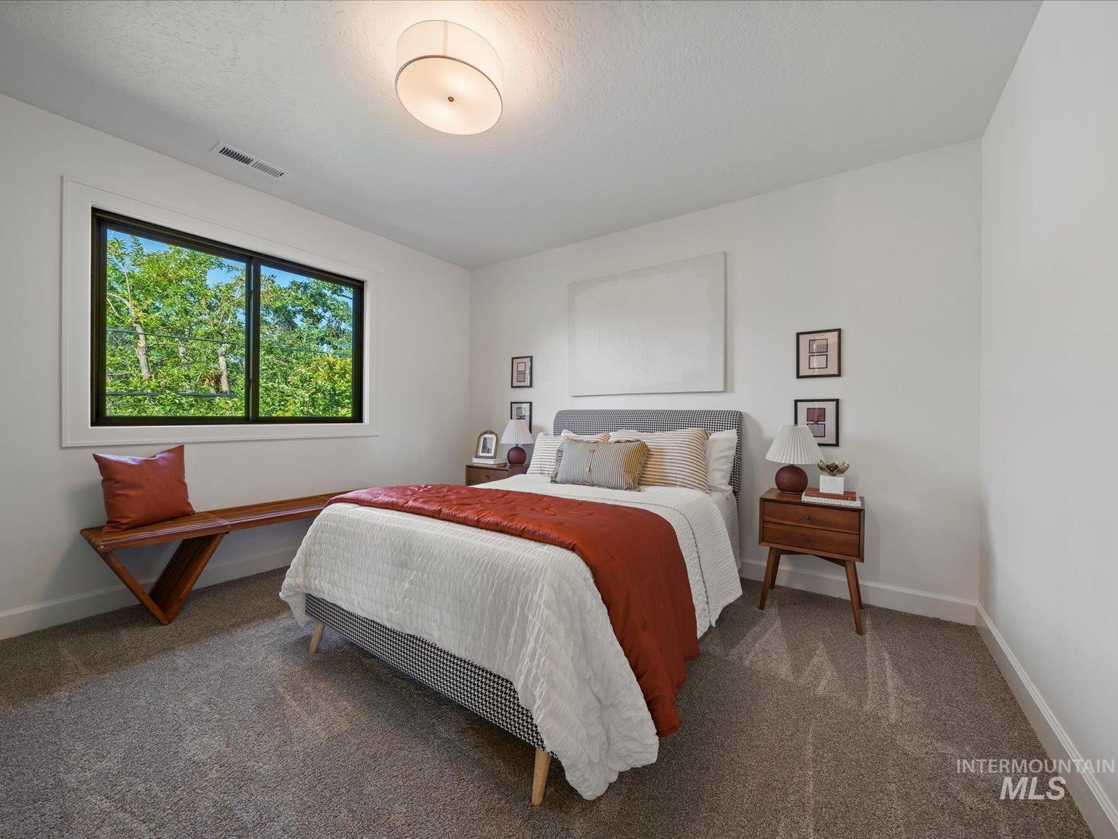 Carpeted bedroom with baseboards and a textured ceiling
