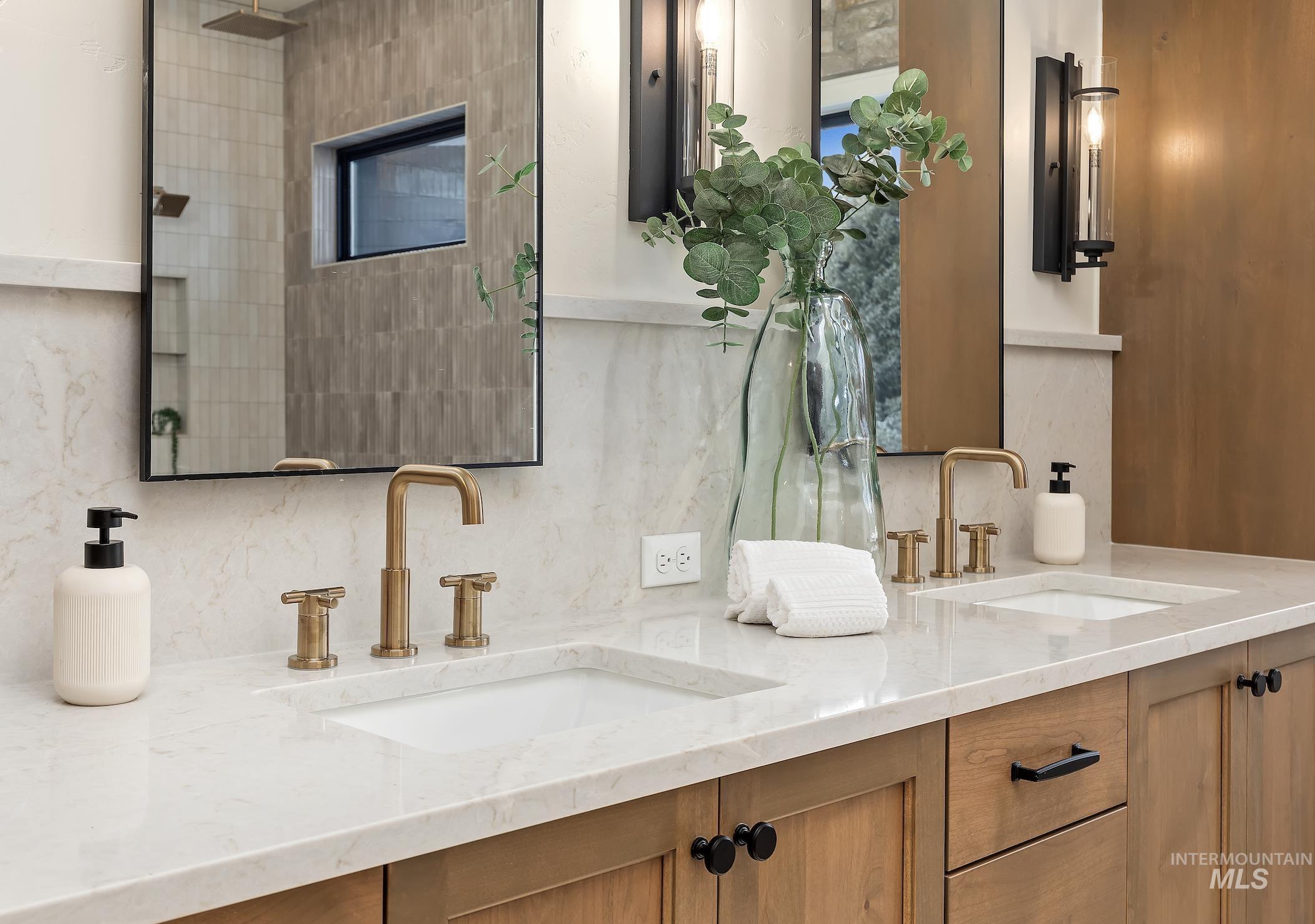 Bathroom featuring double vanity and backsplash