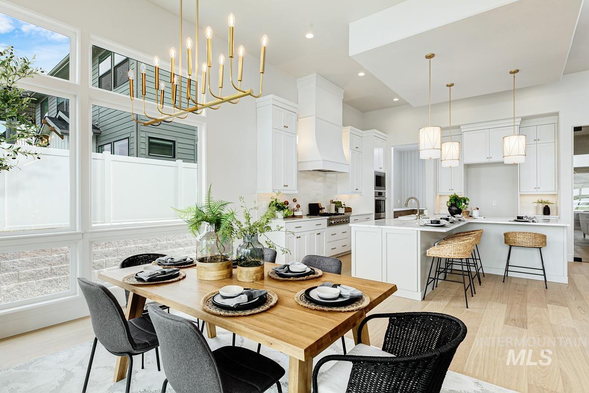 Dining area featuring light wood-style flooring, recessed lighting, and a chandelier