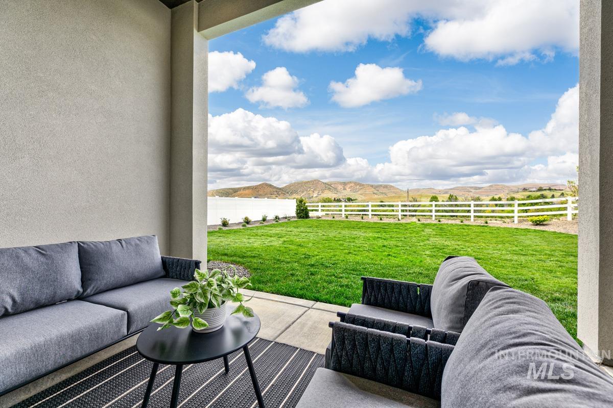 Fenced backyard featuring an outdoor living space, a patio area, and a mountain view