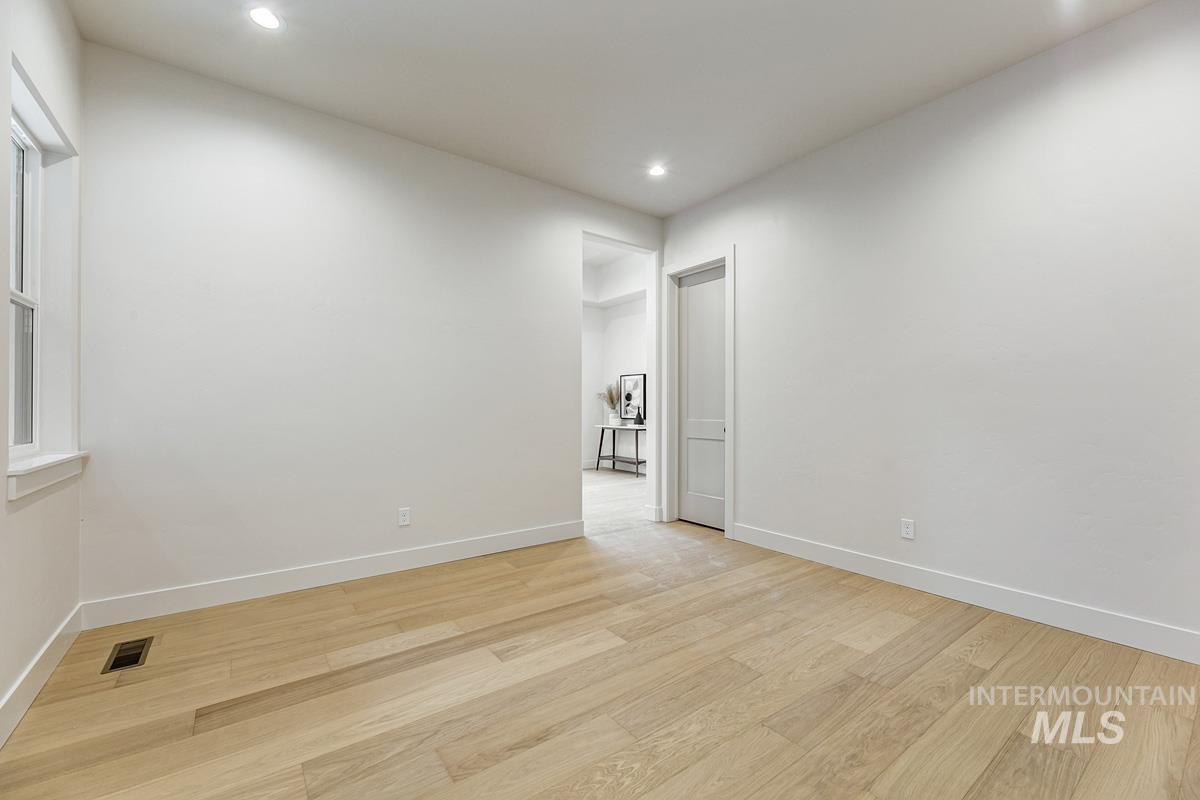 Unfurnished room with wood finished floors and recessed lighting