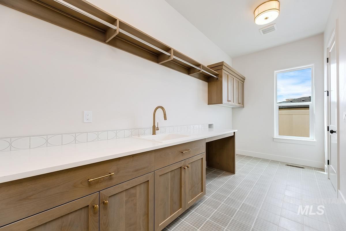 Laundry room featuring cabinet space, light tile patterned floors, and washer hookup