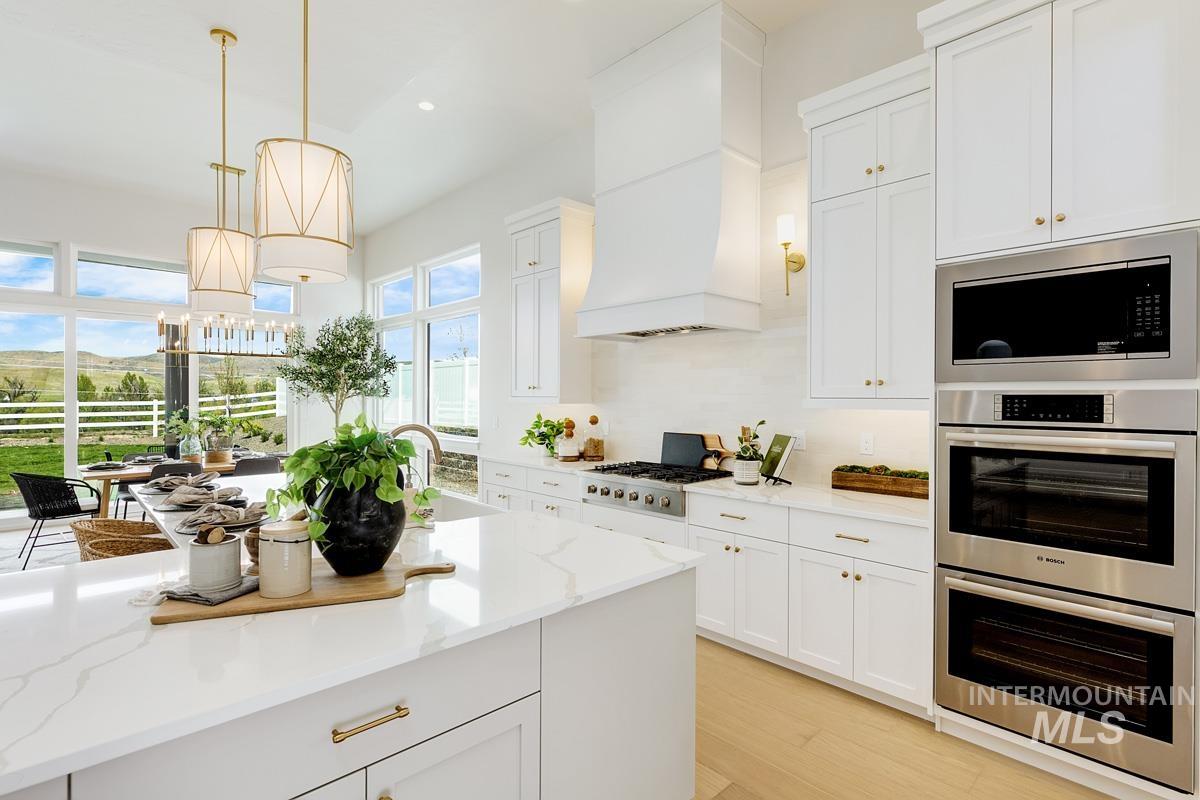 Kitchen featuring appliances with stainless steel finishes, white cabinets, and recessed lighting