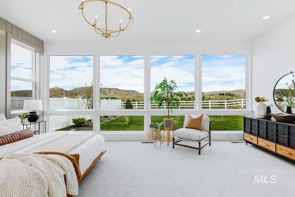 Carpeted bedroom featuring a mountain view, recessed lighting, and a chandelier
