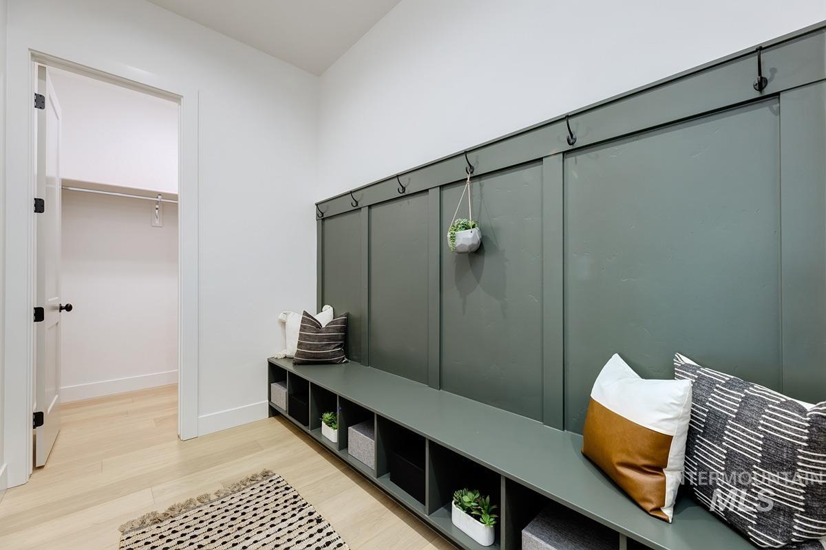 Mudroom featuring light wood-style flooring and baseboards