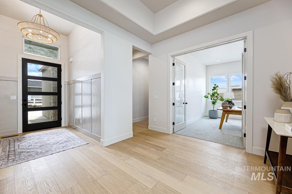 Entryway with light wood-style flooring and a chandelier