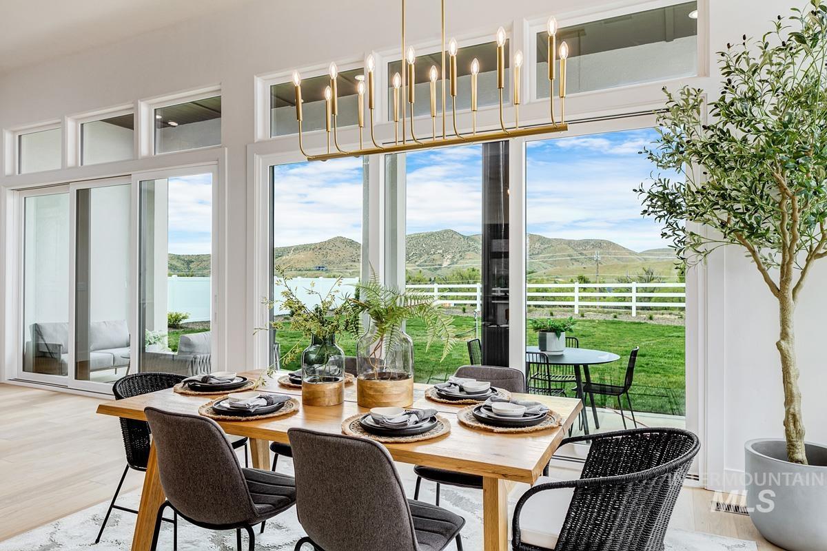 Dining room featuring a mountain view, light wood finished floors, and a chandelier