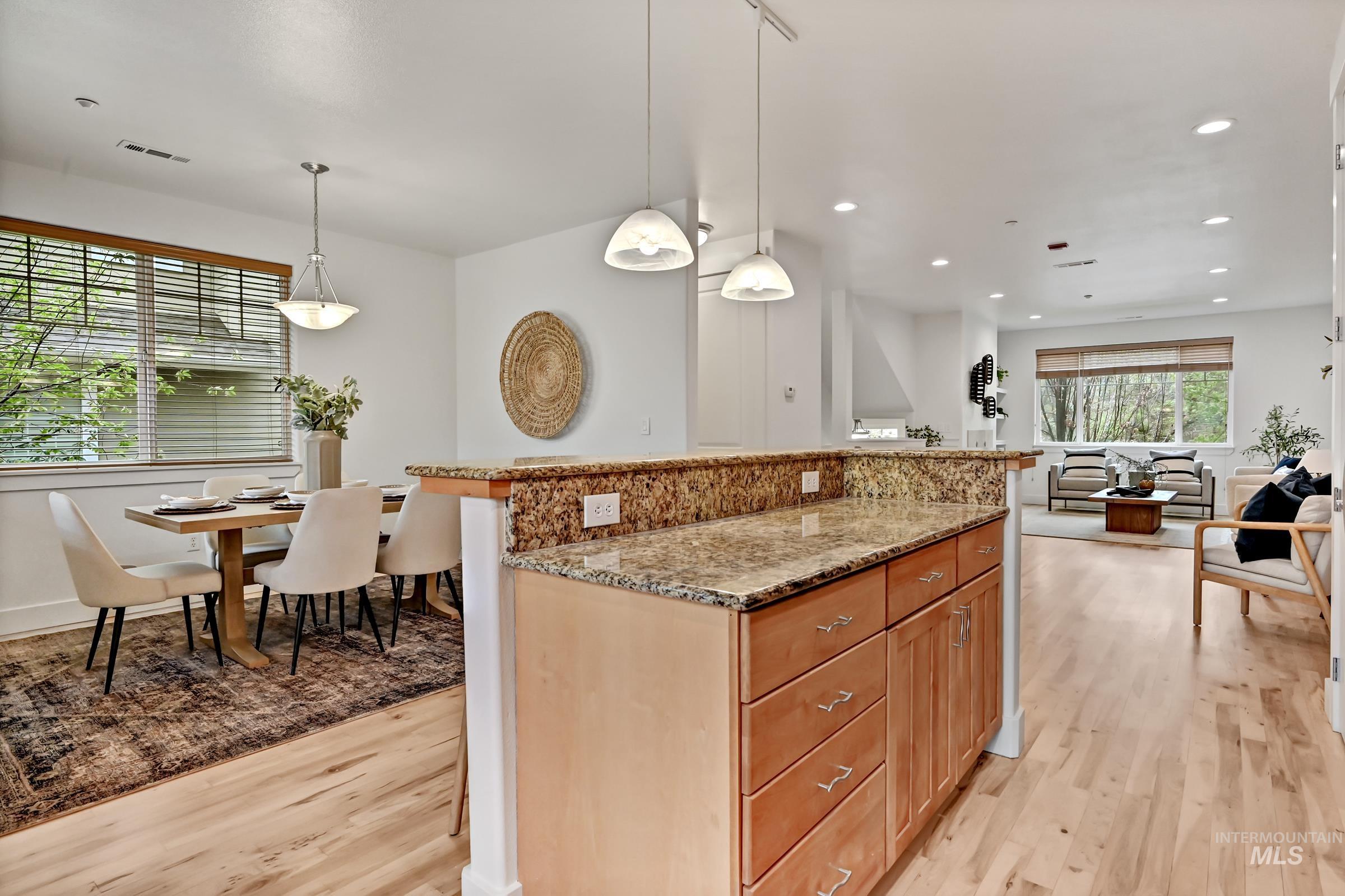 Kitchen with granite counters, center island, and pendant lighting. Ample cabinetry. Open layout for gathering that leads to the dining area and deck.