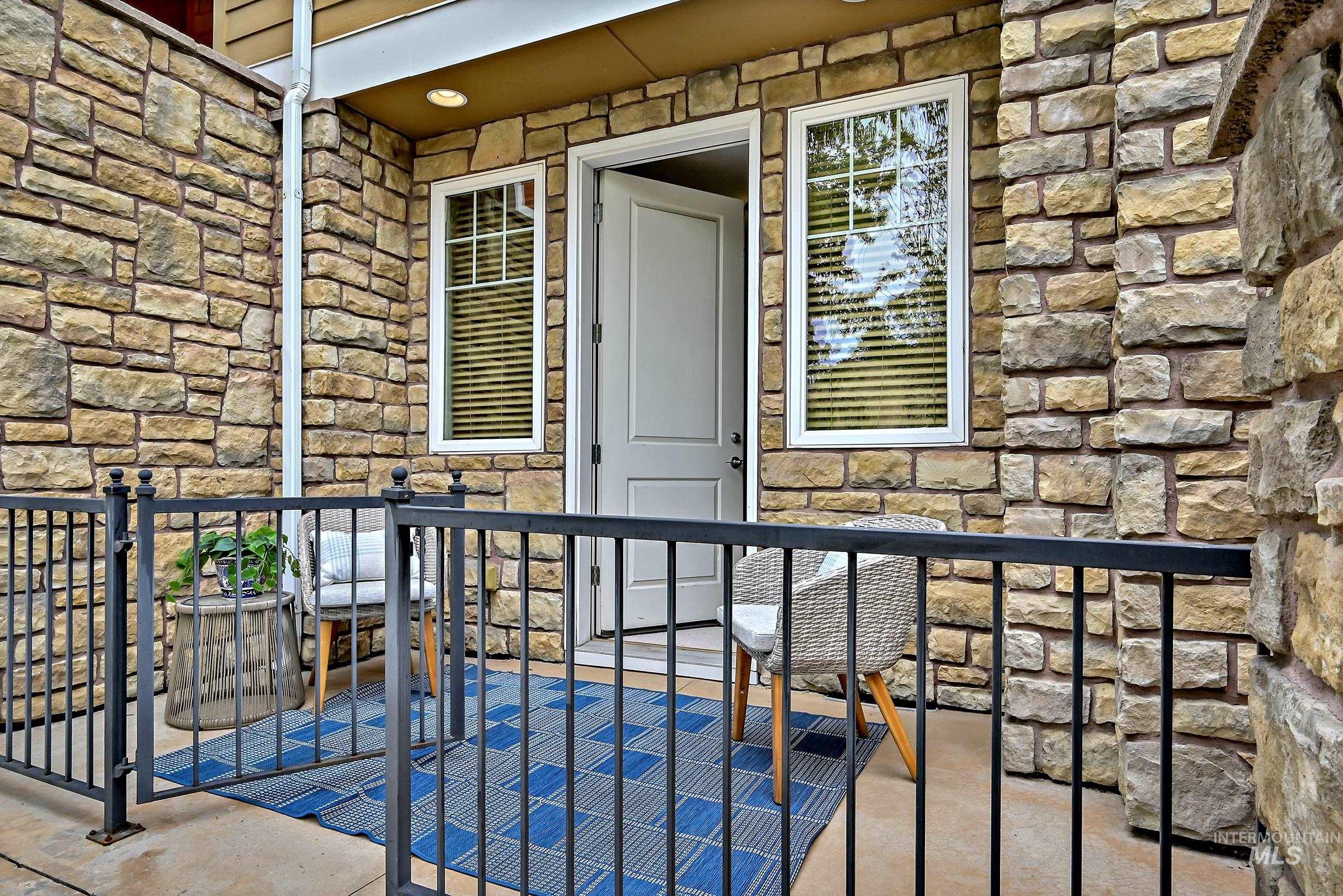 Ground-level patio off the bedroom with railing and space for outdoor seating. Great area for relaxing or dining with a view across the street toward foothills trails.