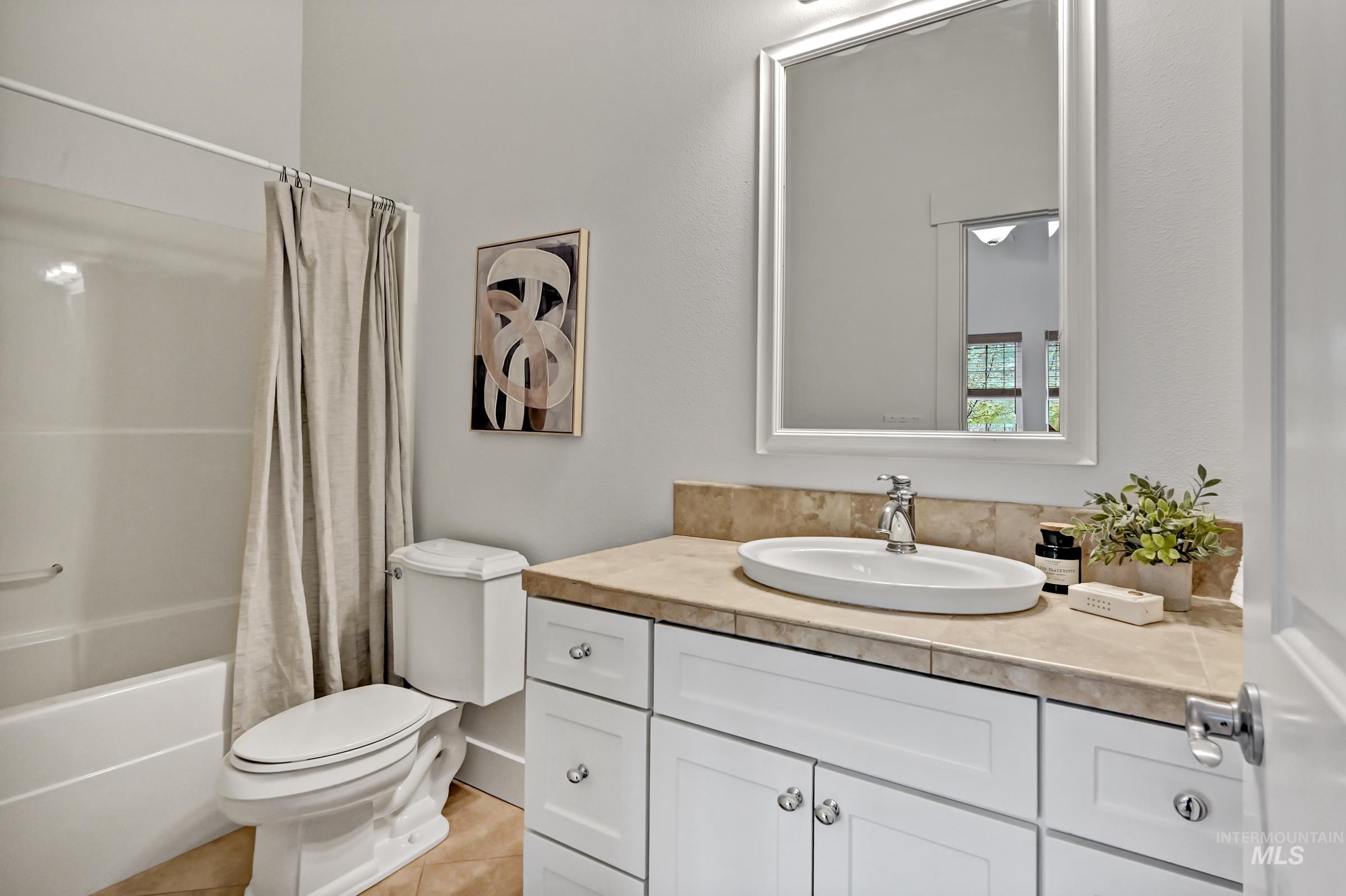 Ensuite bathroom with tub/shower combo, vanity, large mirror, and clean finishes. Bright, functional layout.