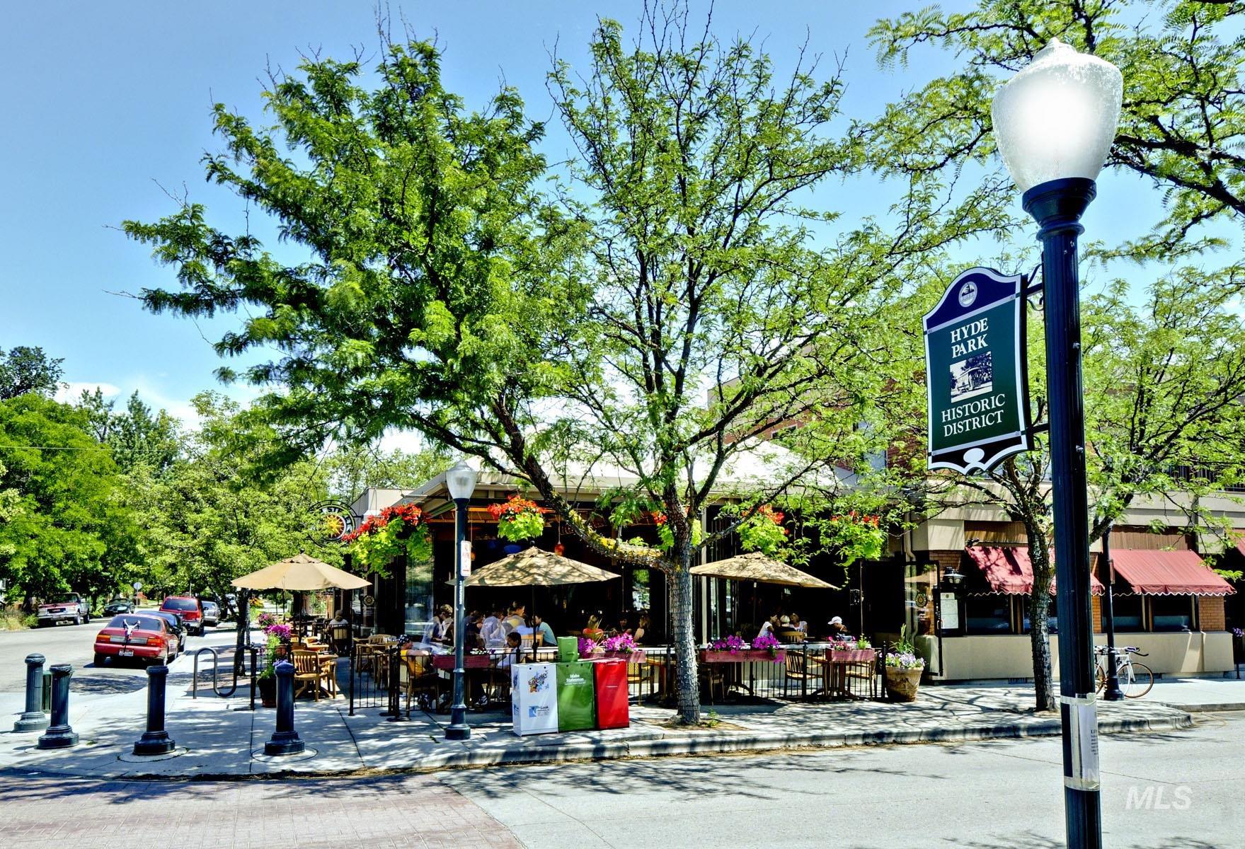 Outdoor dining area with umbrellas and seating. Lively space for gatherings. Nearby Hyde Park shops, restaurants, and coffee shops