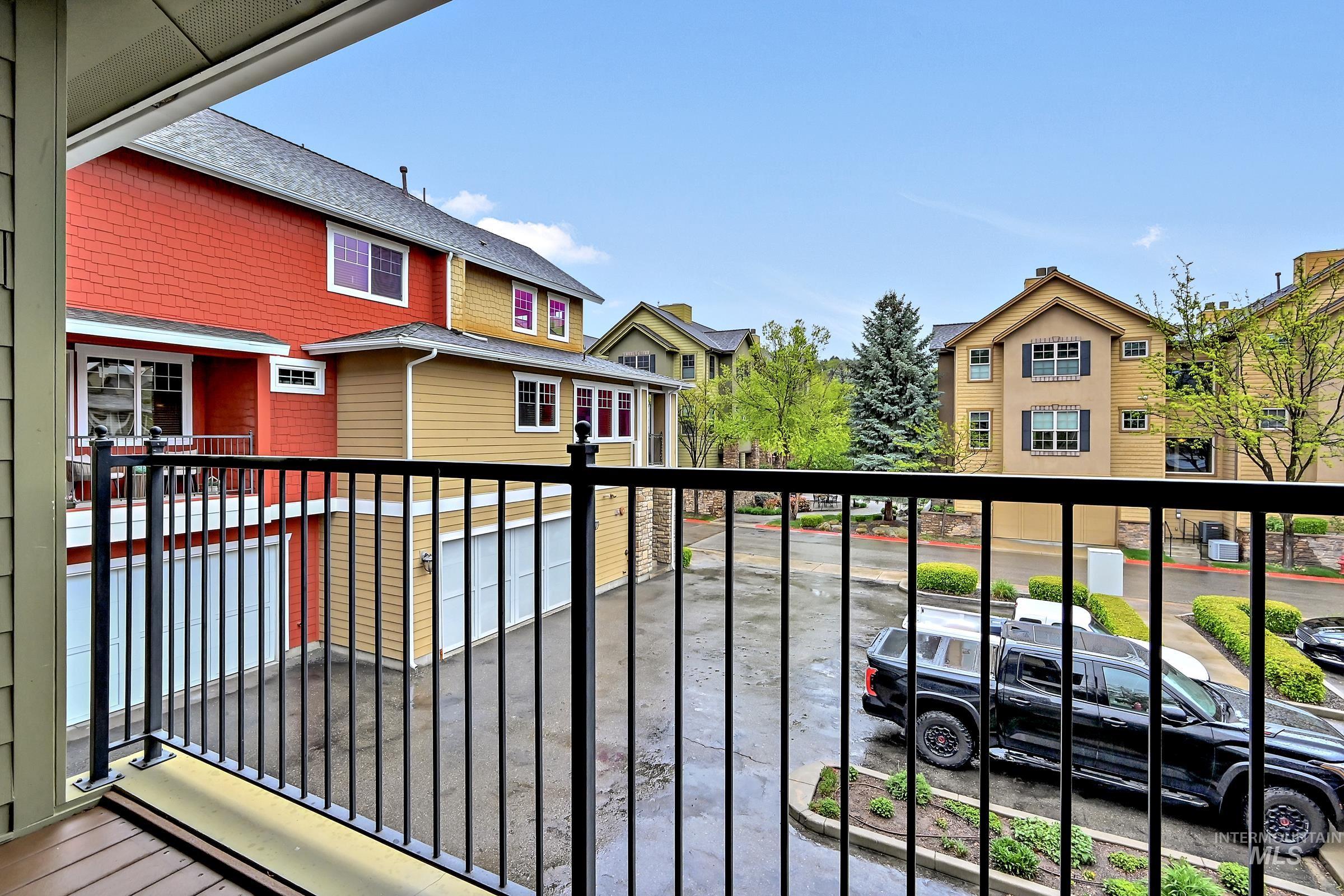 Covered deck with railing and neighborhood views. Comfortable outdoor space for relaxing.
