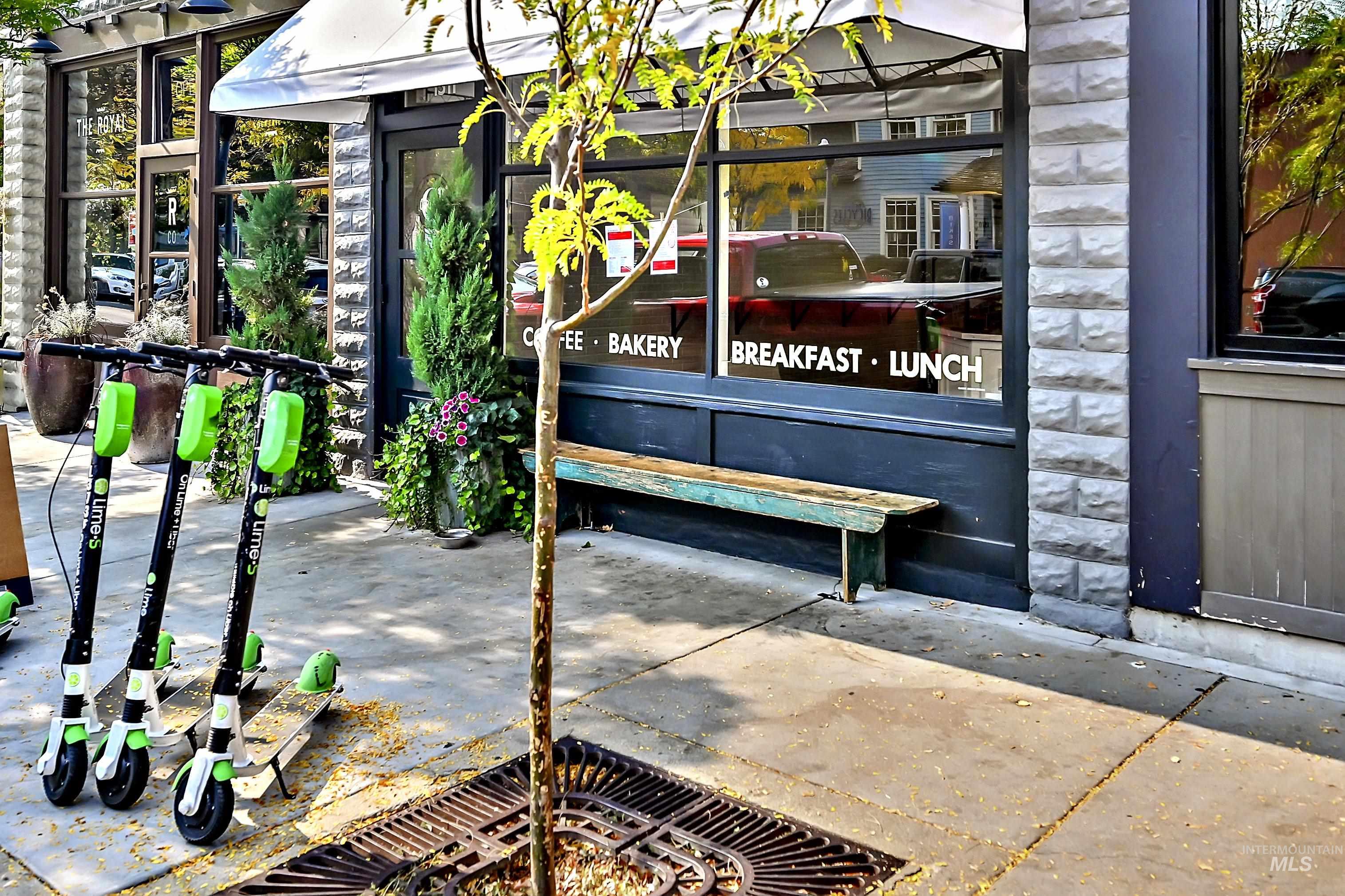 Row of parked scooters in front of a Hyde Park business. Urban setting with convenient nearby amenities.