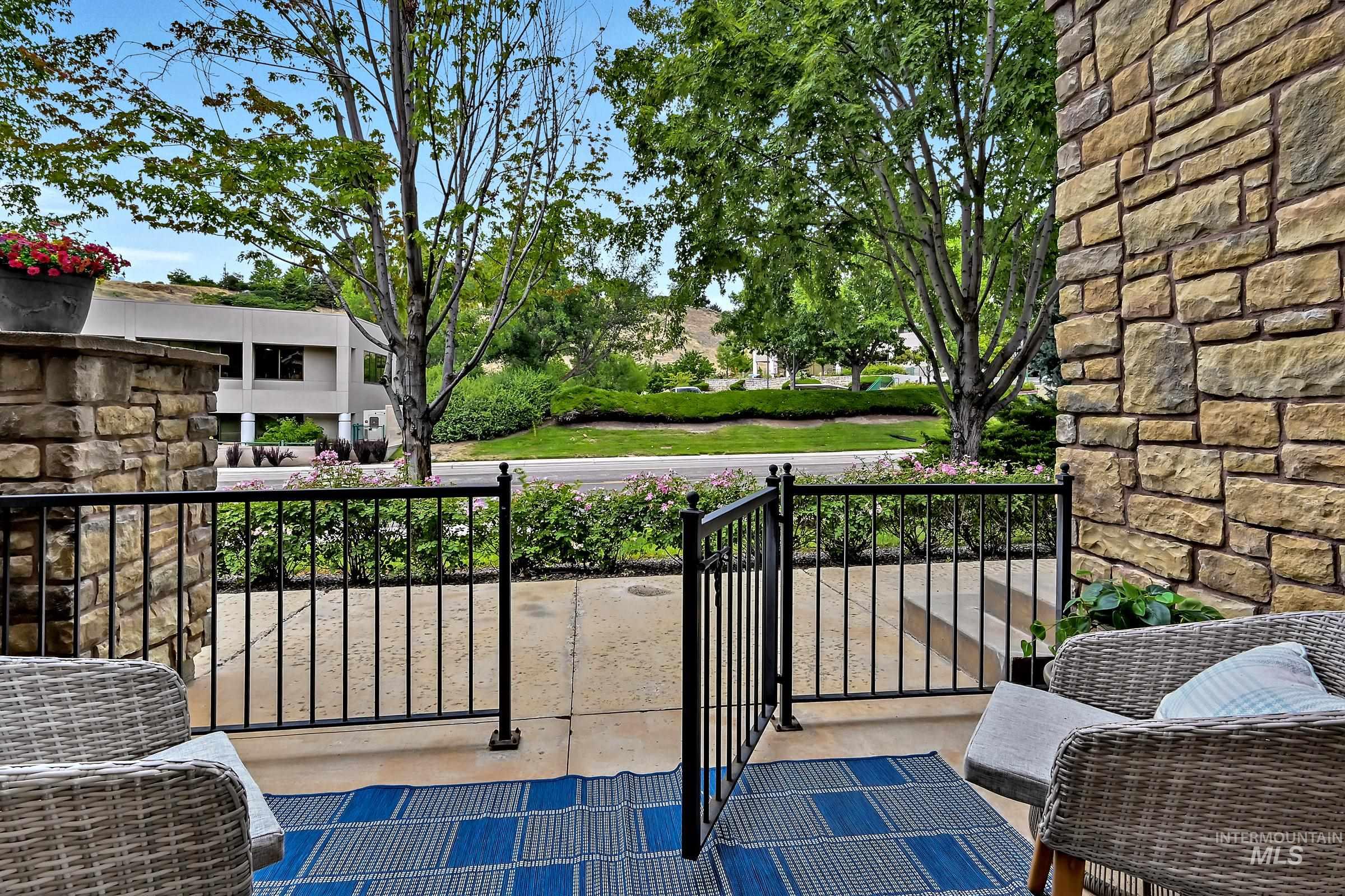 Ground-level patio off the bedroom with railing and space for outdoor seating. Great area for relaxing or dining with a view across the street toward foothills trails.