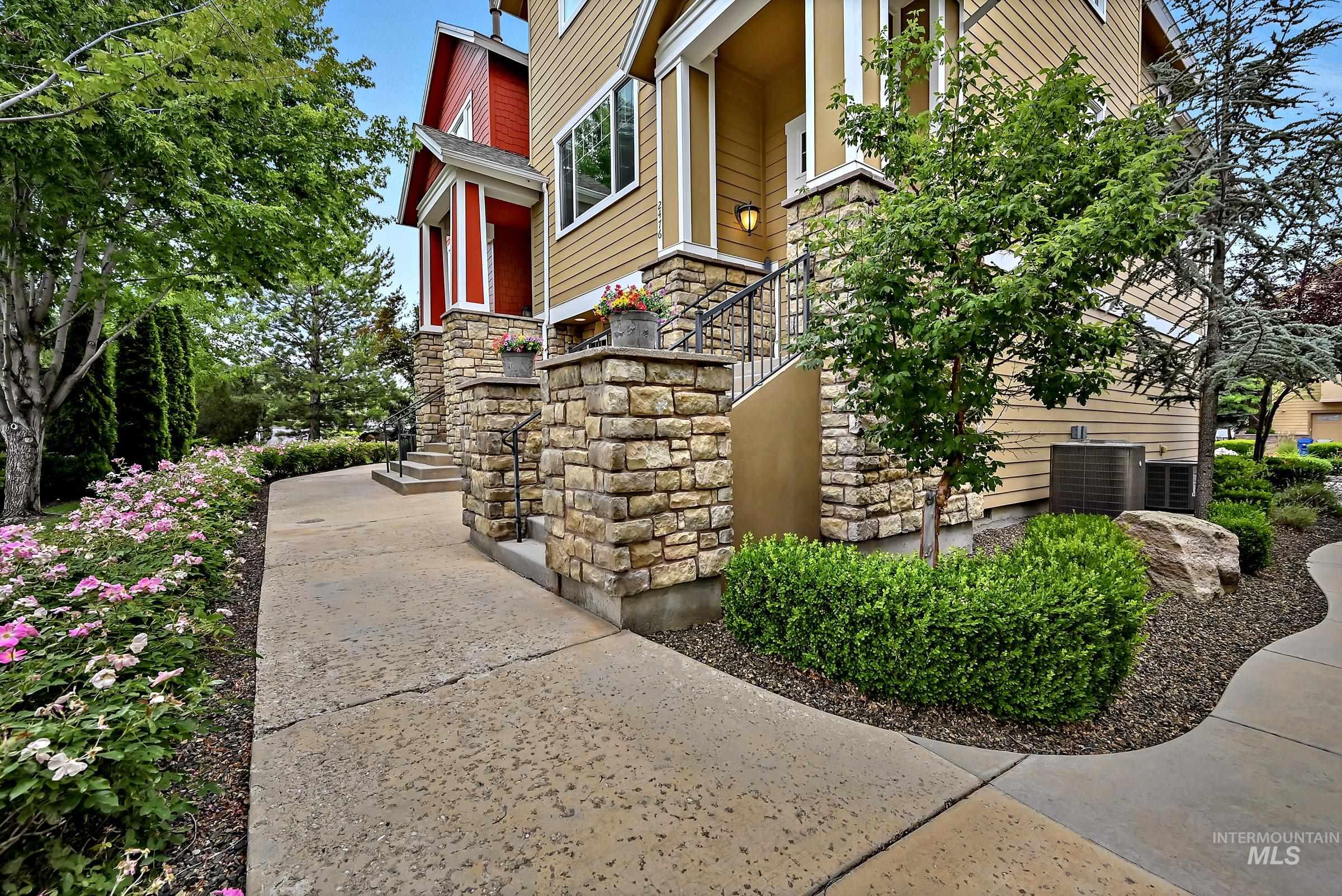 Multi-level townhome exterior featuring stone accents and a covered entry