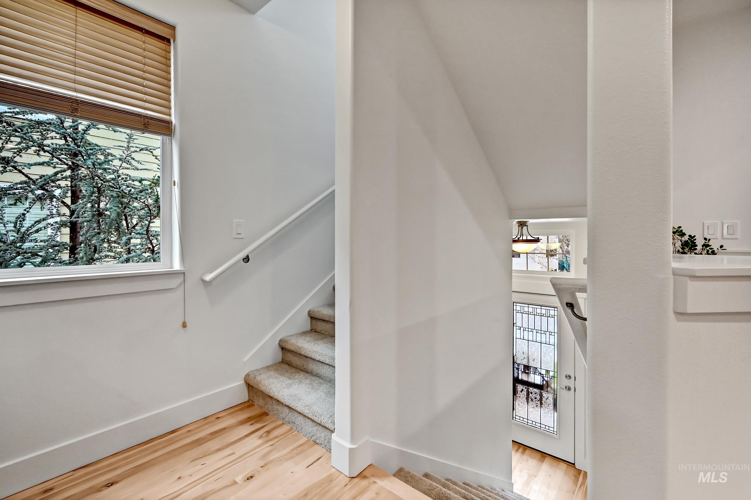 Well-lit stairwell landing with hardwood flooring. Clean, simple transition between levels.