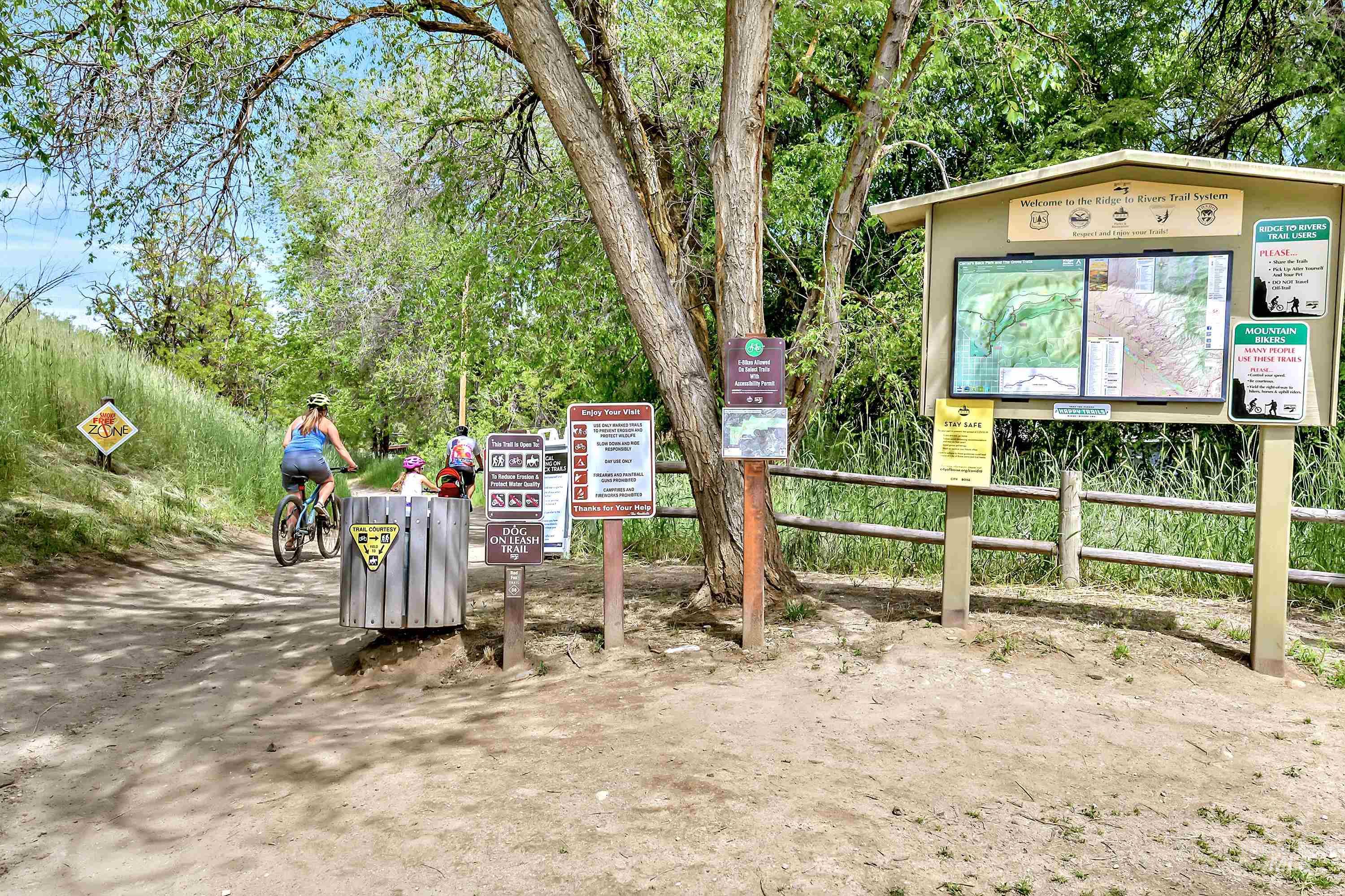 Near by foothills trailhead with cyclists on the trail and a mounted trail map