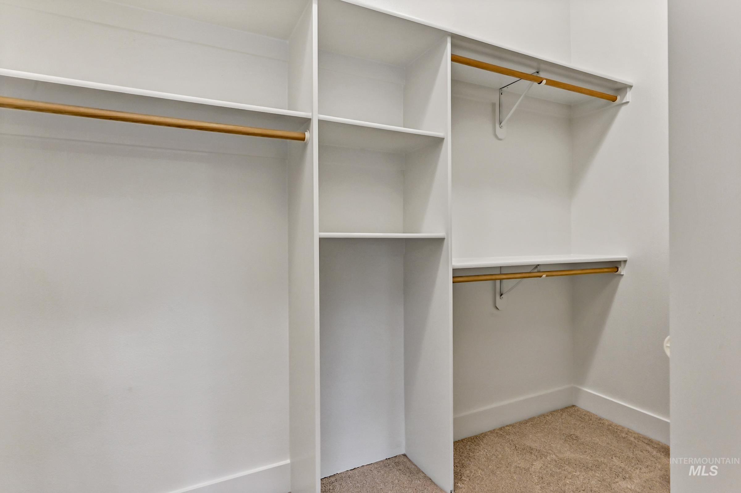 Walk-in closet with built-in shelving and ample storage. Organized and functional layout.